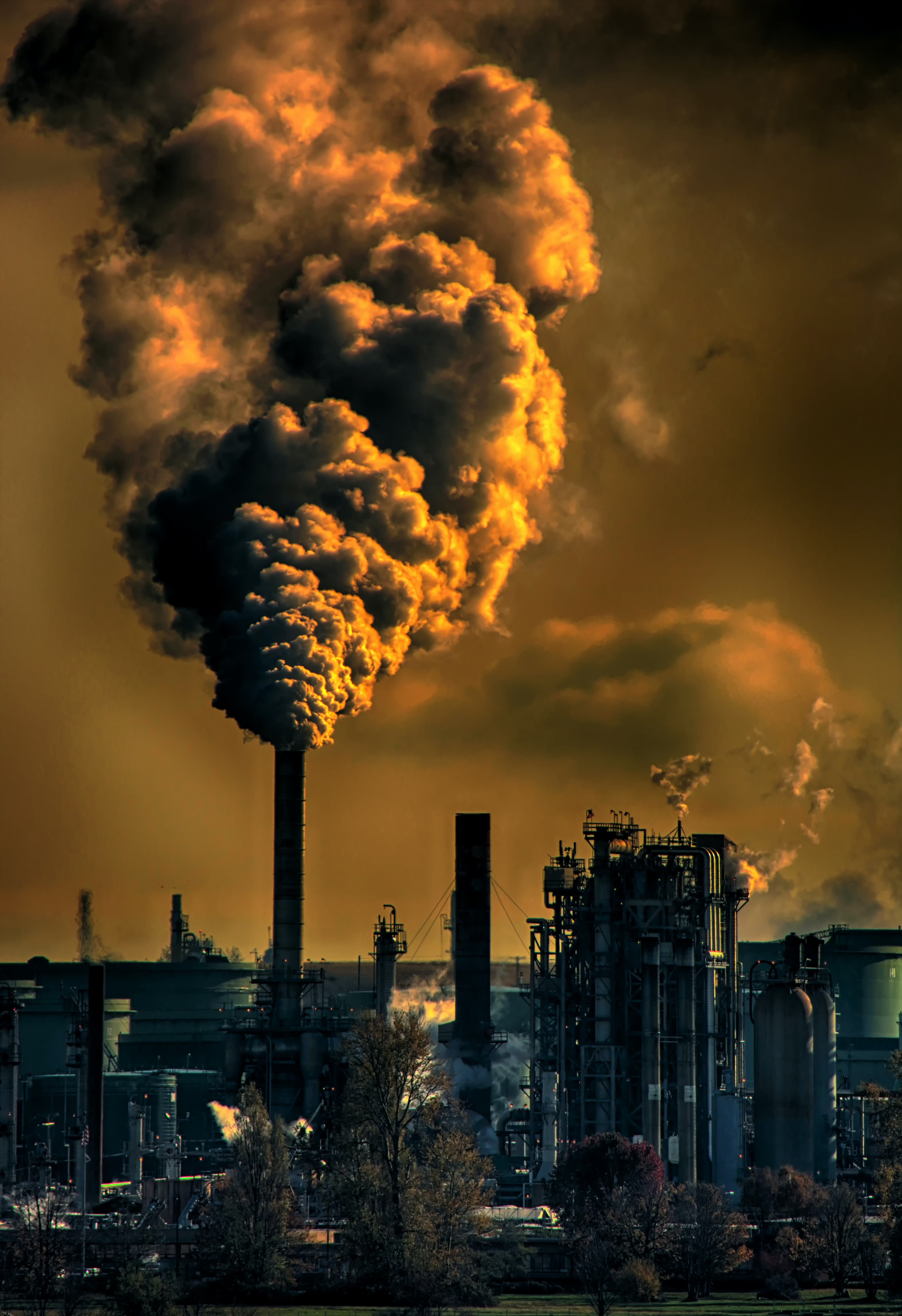 Smoke stacks with pollution coming out of industrial area.
