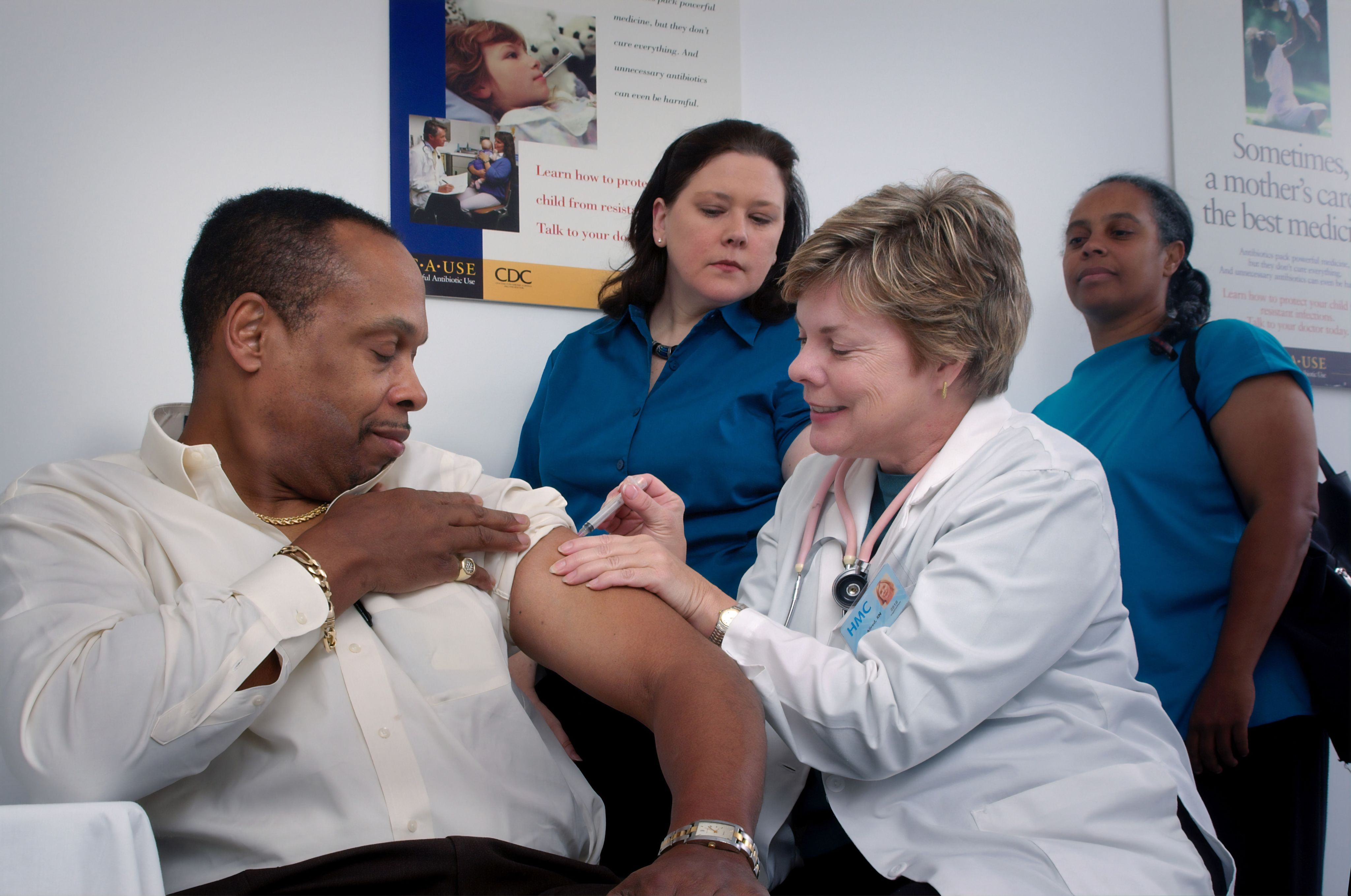 An older black man being given a COVID 19 vaccine.