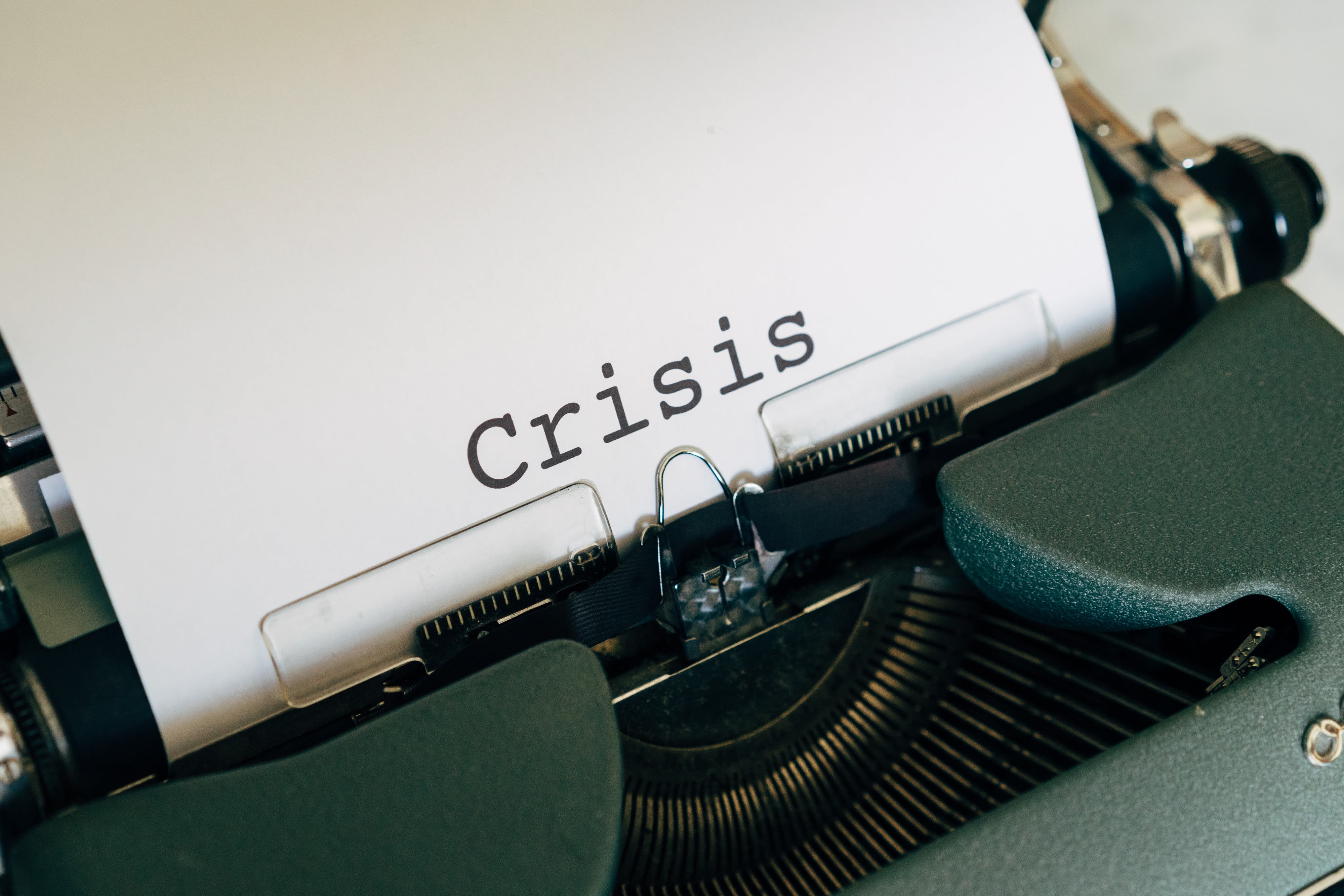 Old fashioned typewriter with the word "Crisis" typed onto white paper.