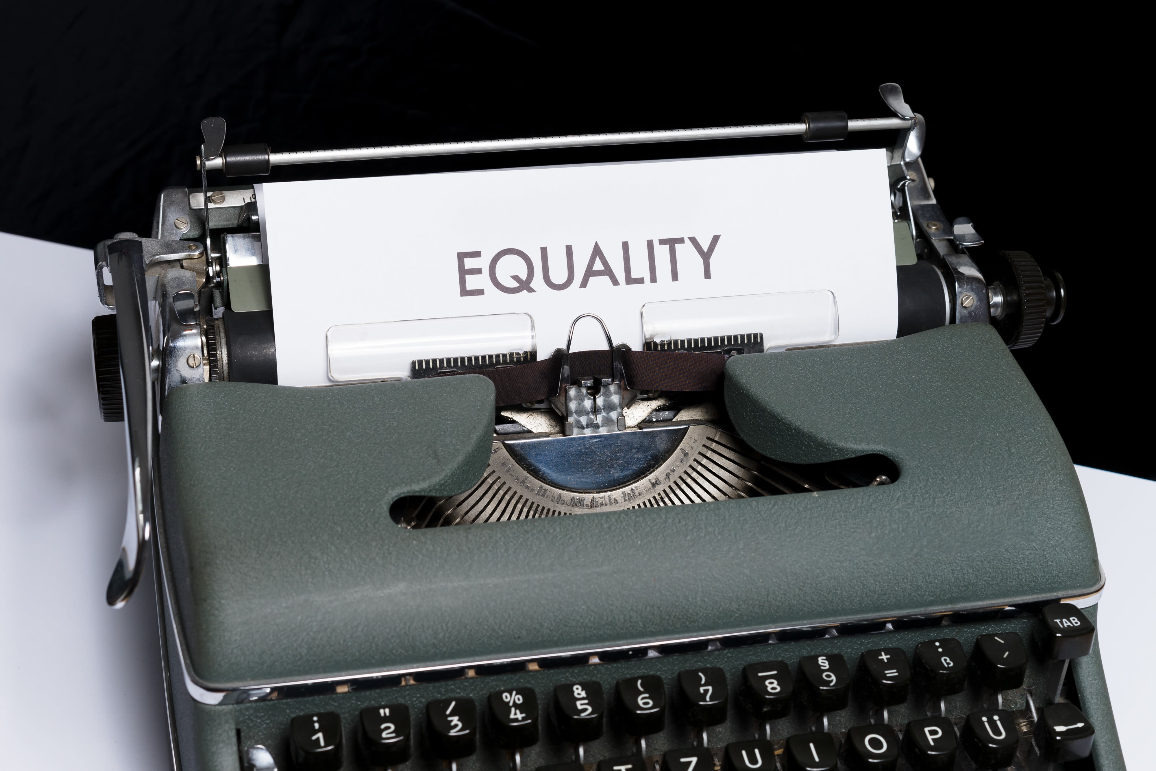 Old fashioned typewriter with a piece of paper that reads "EQUALITY" in big bold capital letters.