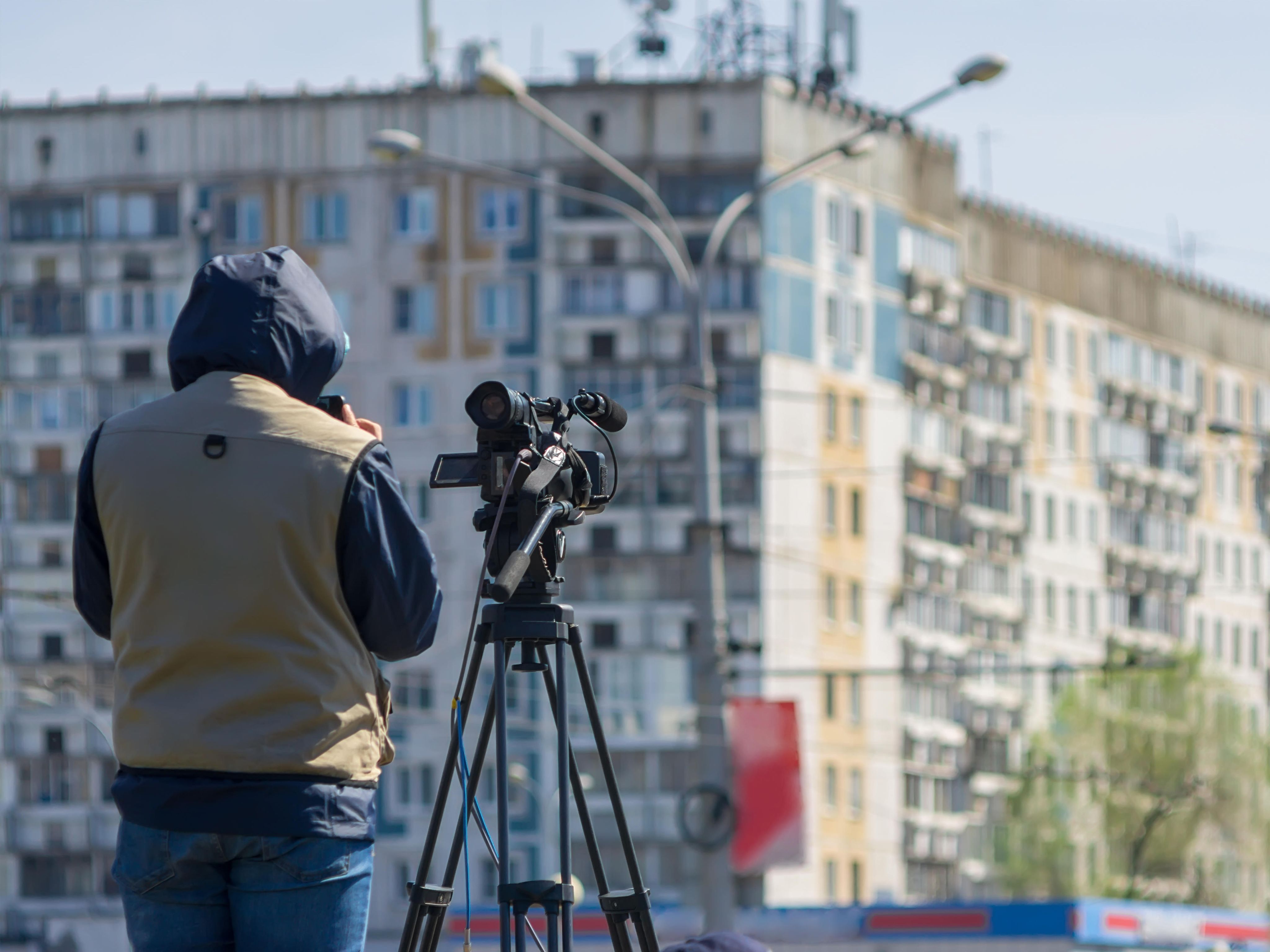 Tv camera operator in front of building