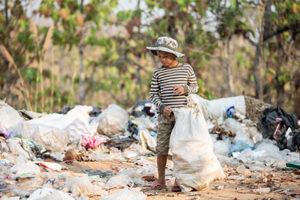 Young boy picking litter from a beach