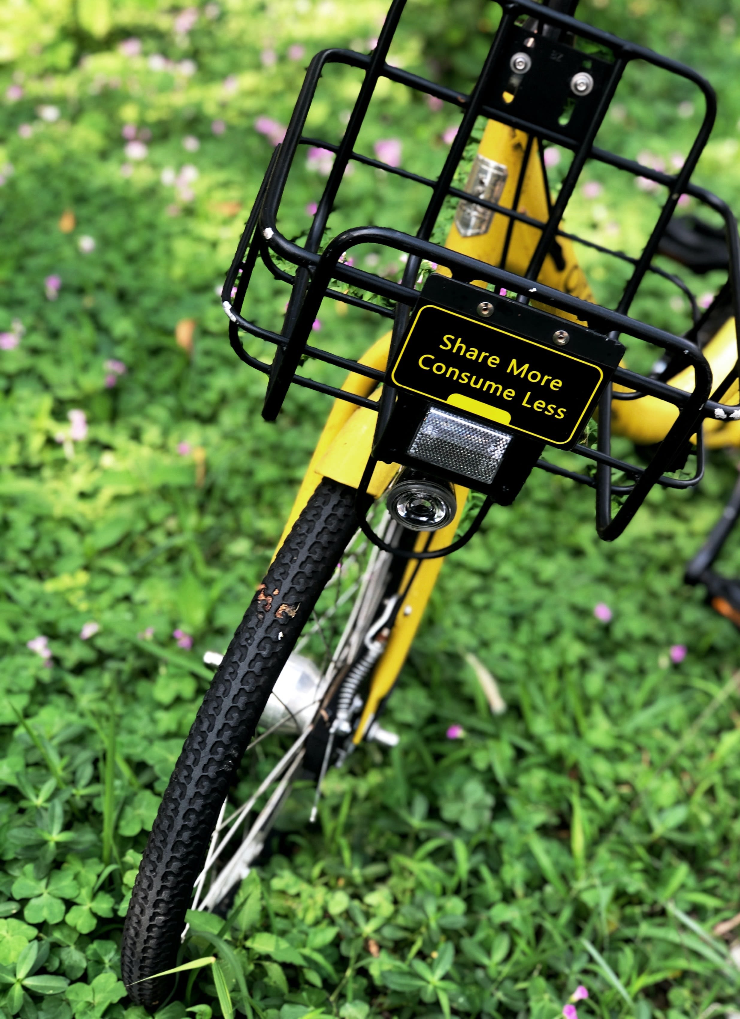 Bicycle with sign: Share more, consume less.
