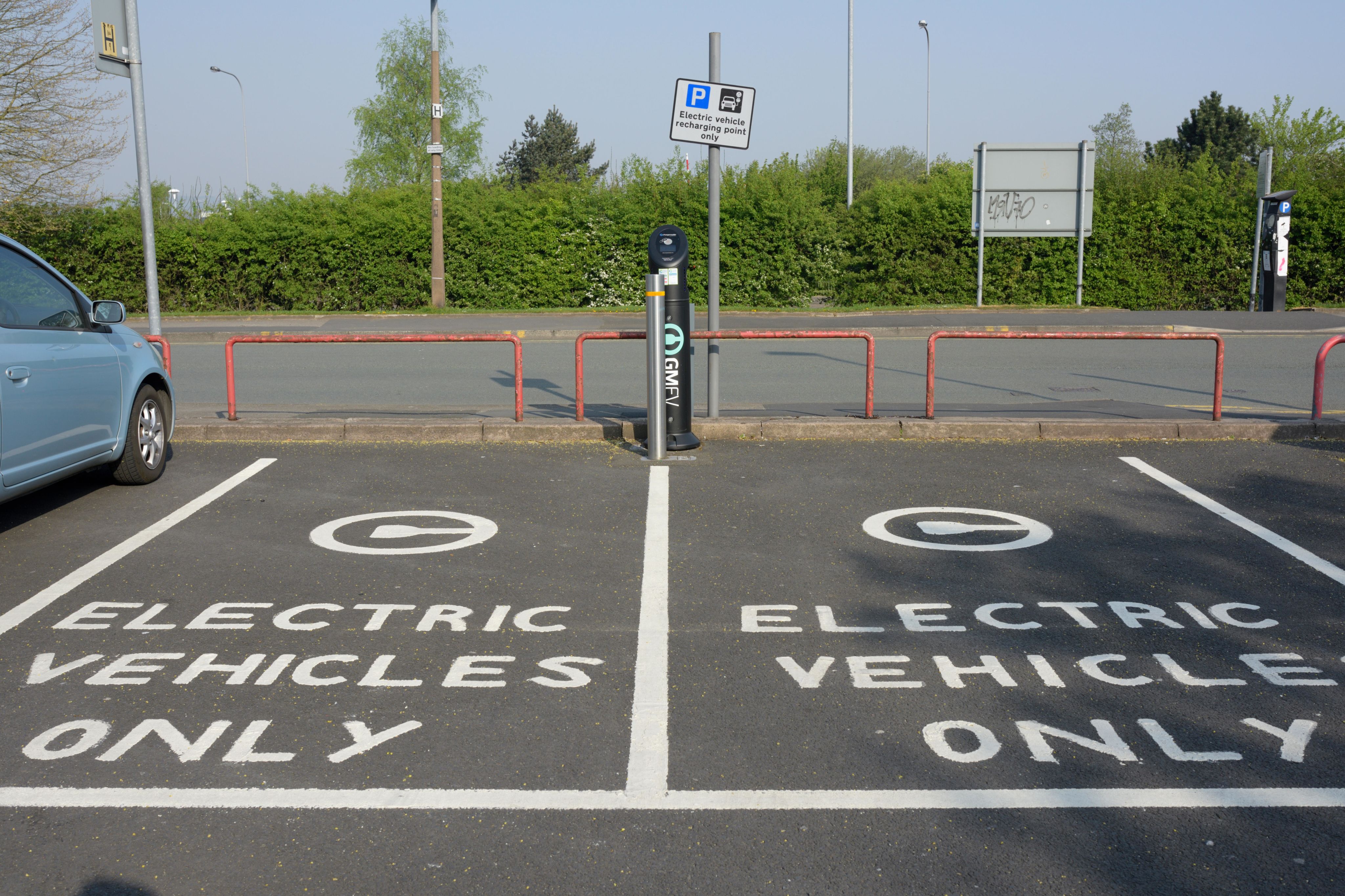 Parking lot with white paint on 2 parking spots that says "Electric vehicles only"