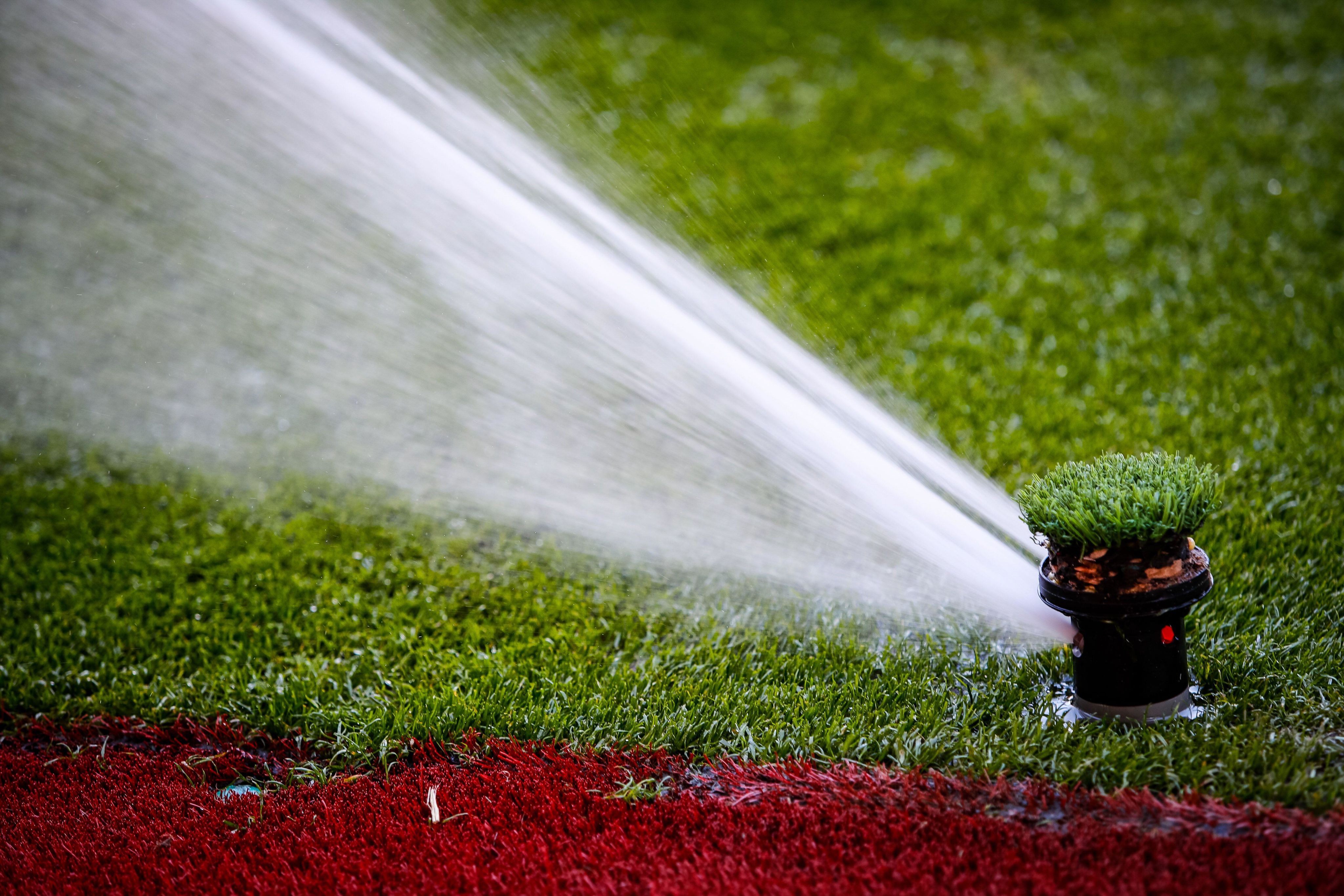 A sprinkler waters a soccer pitch