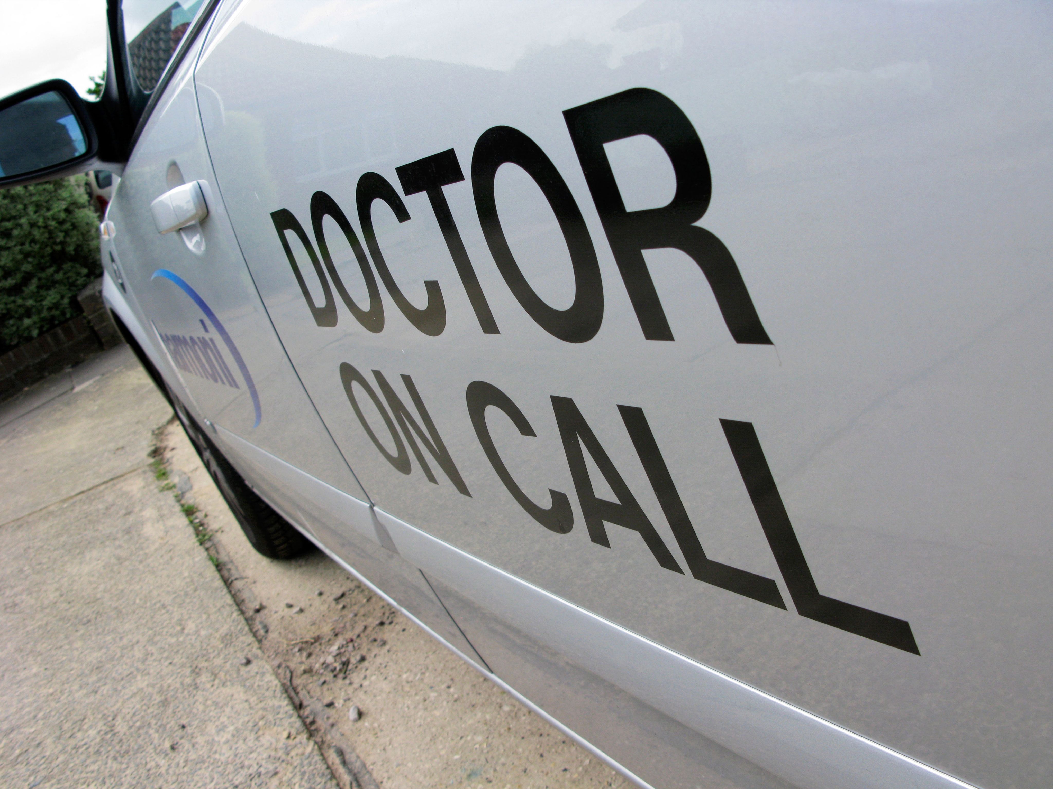 Shot of the side of a car with 'Doctor on Call' written on door