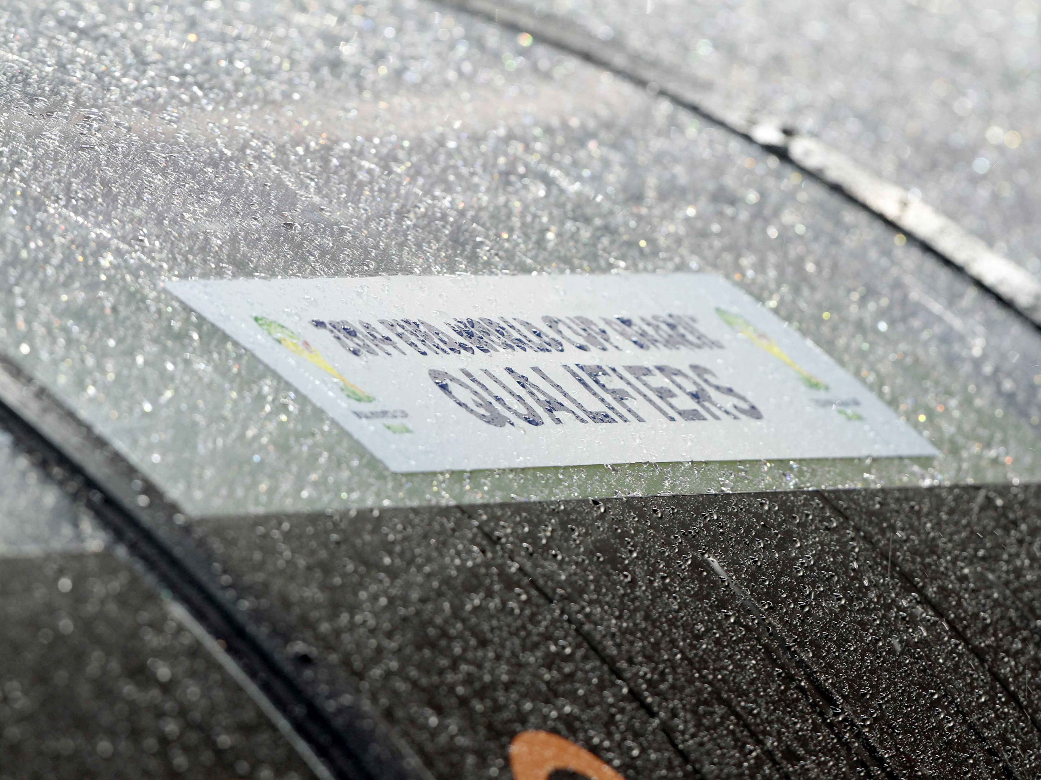 Rain on FIFA sign on football pitch dugout