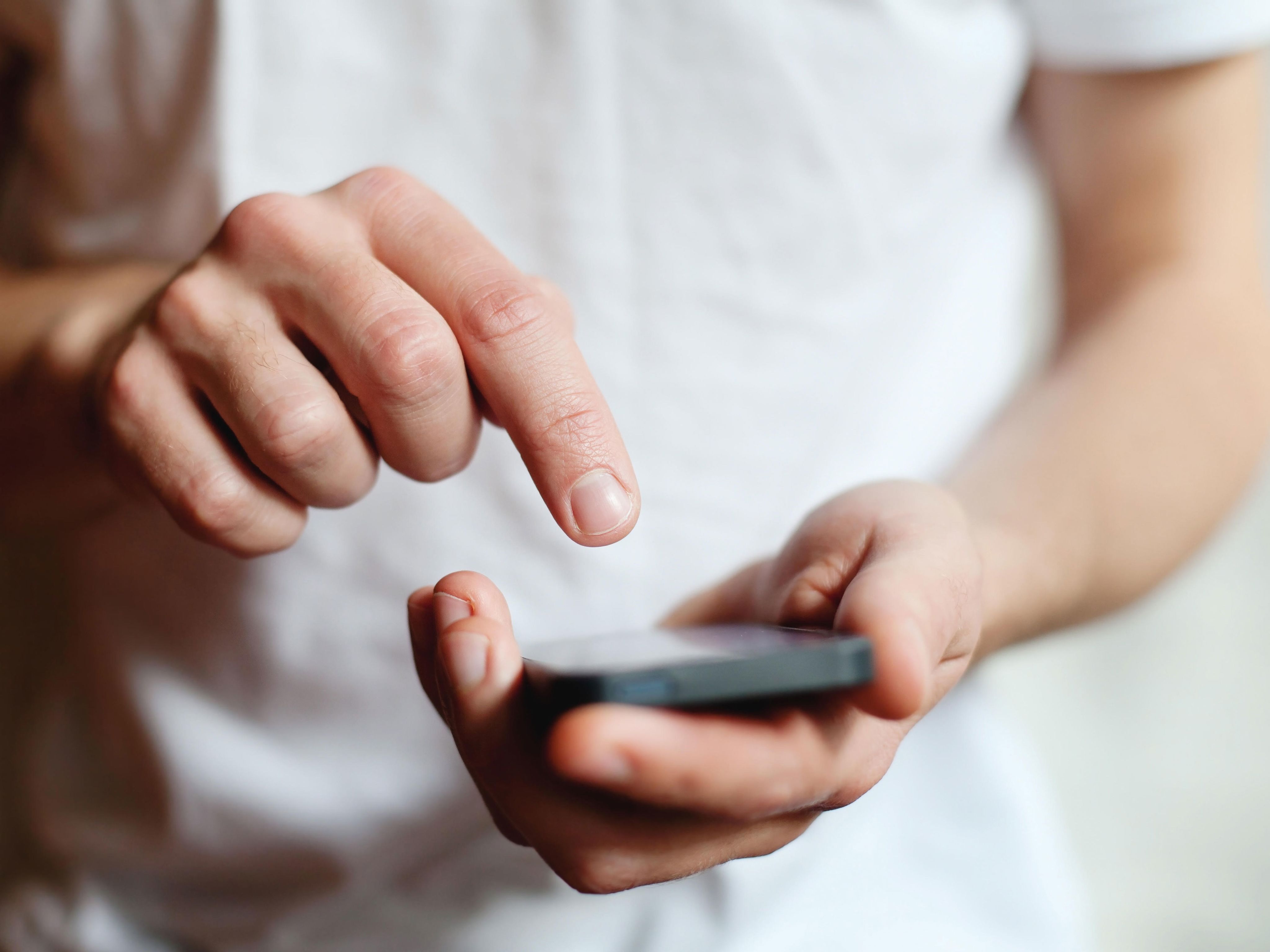 Close up of a person on white clothing using a smartphone