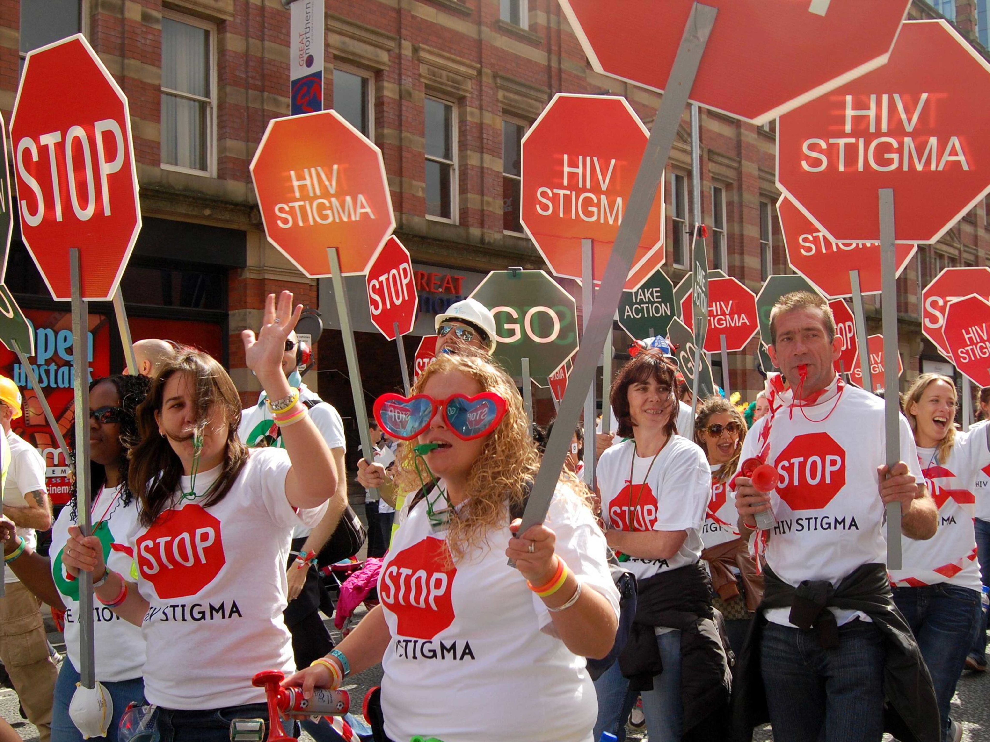 A walking float of people carrying 'Stop HIV' Stigma' placards and wearing t shirts with the same message in Manchester, United Kingdom