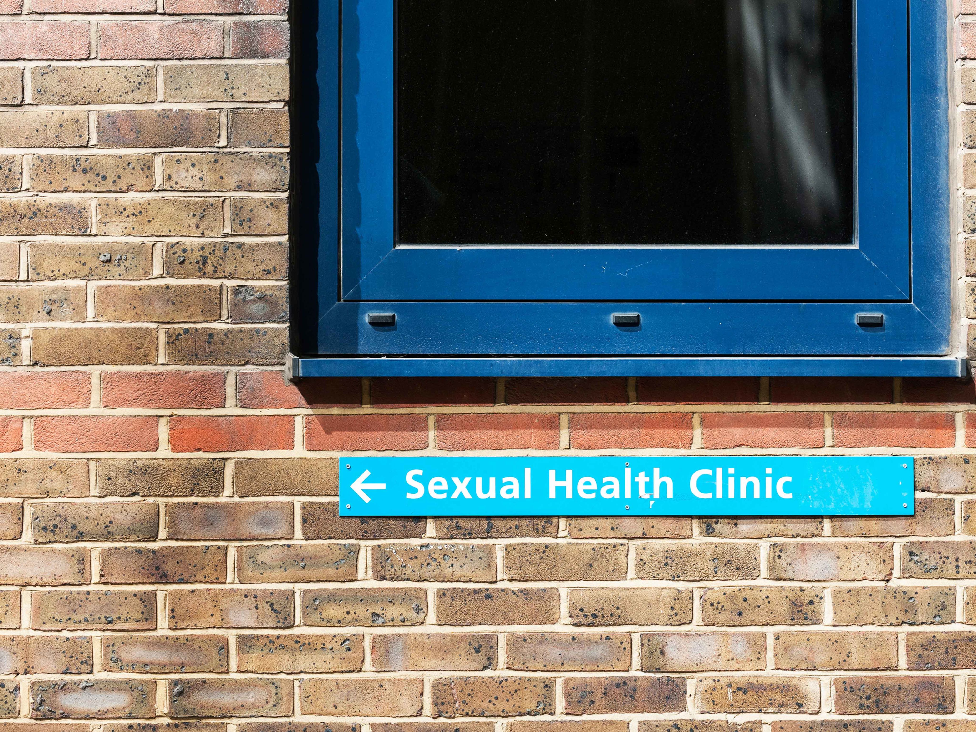 Sexual health clinic sign on a brick wall