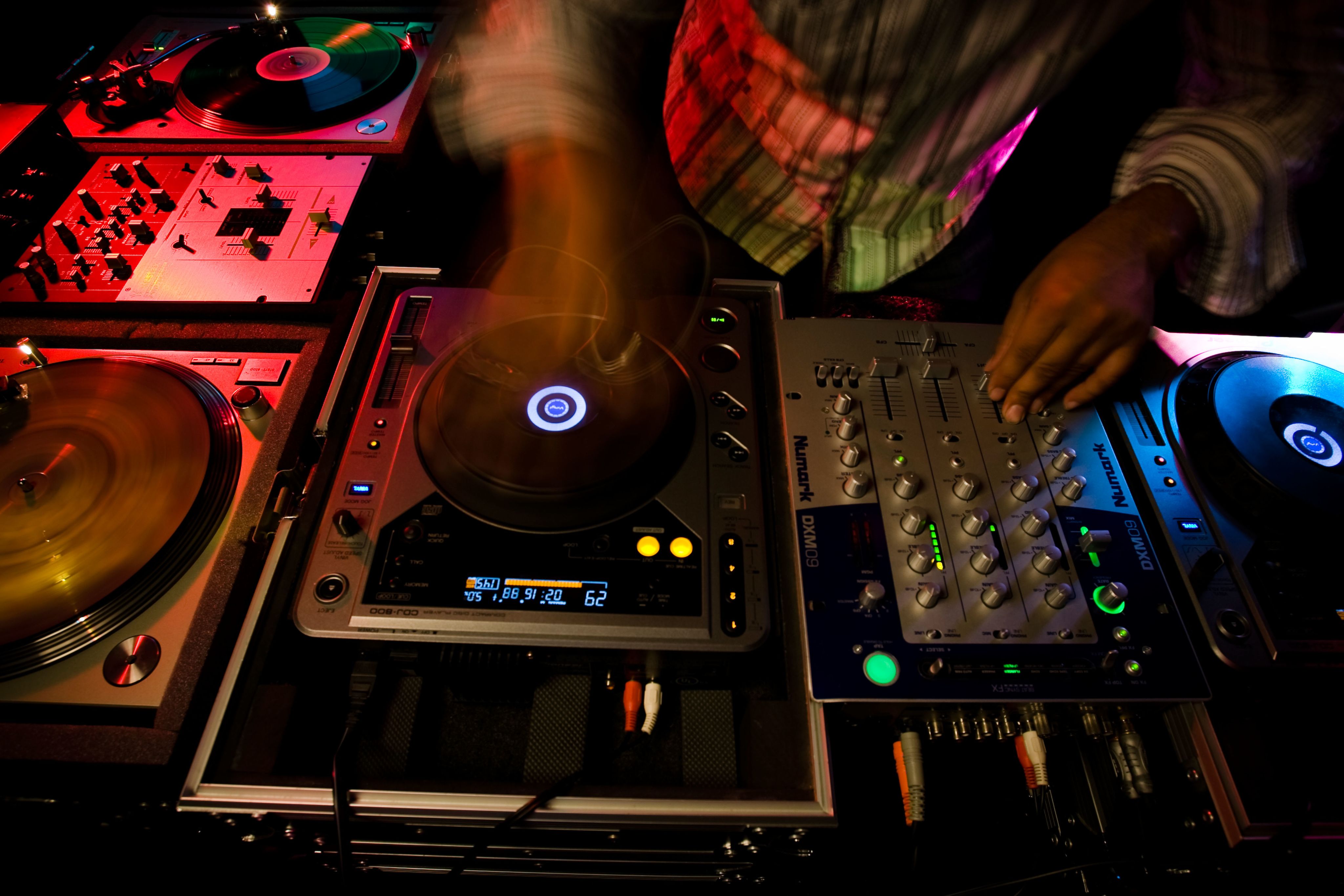 A DJ performing by scratching and manipulating records on a turntable.