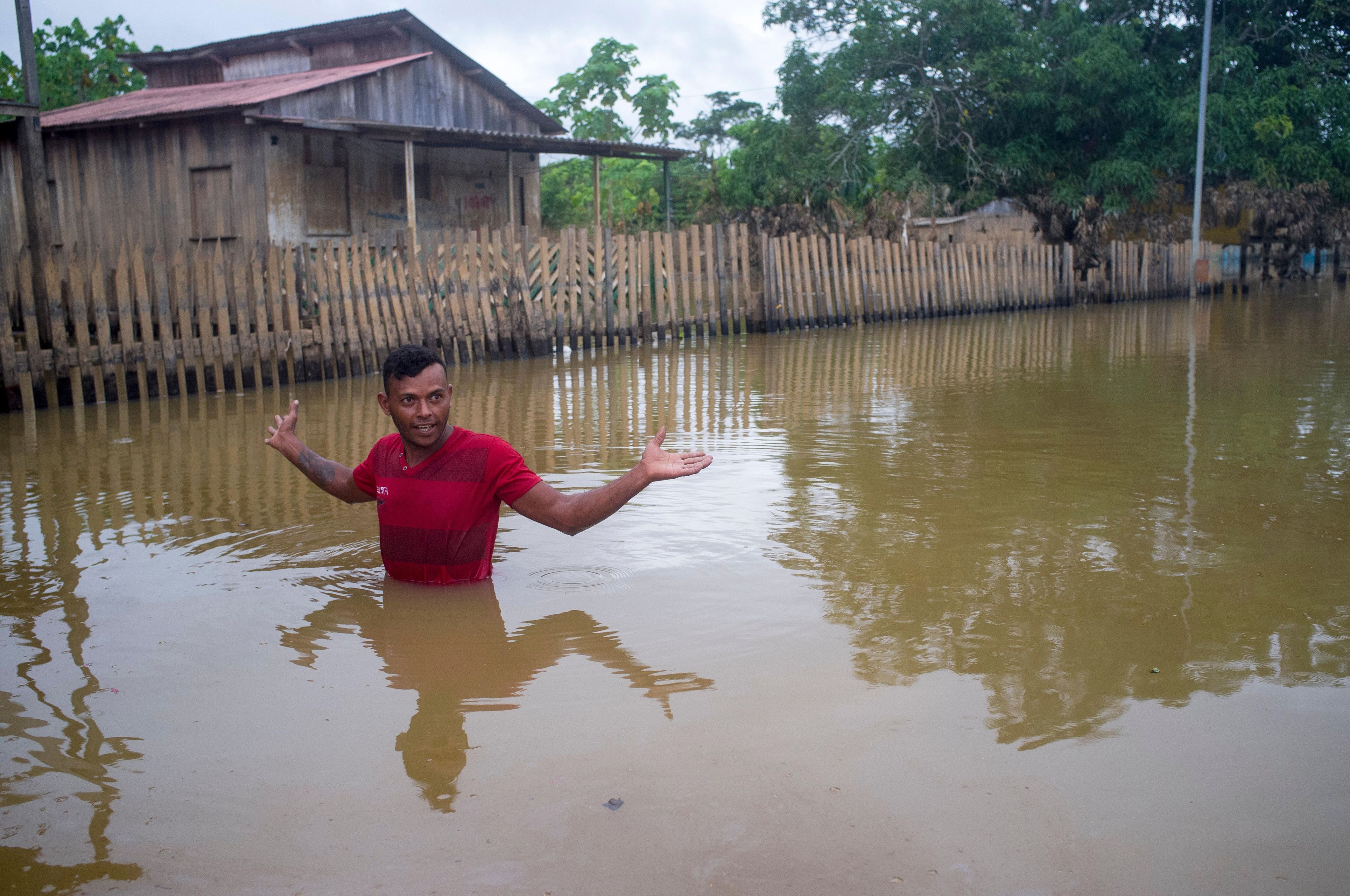 A man wades through a flood in the Amazon region of Brazil