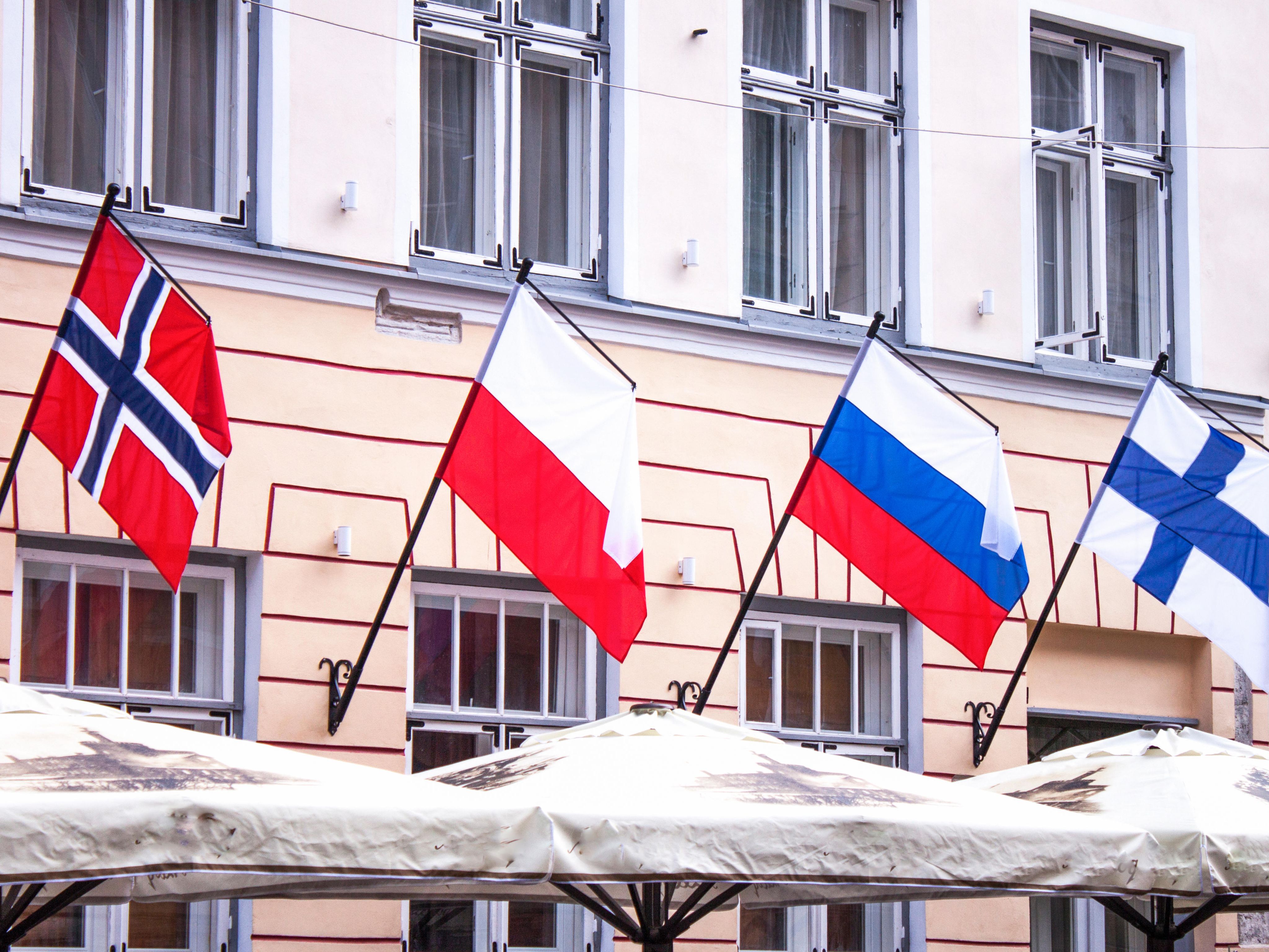 Norway, Poland, Russia, and Finland flags, above a restaurant in Estonia