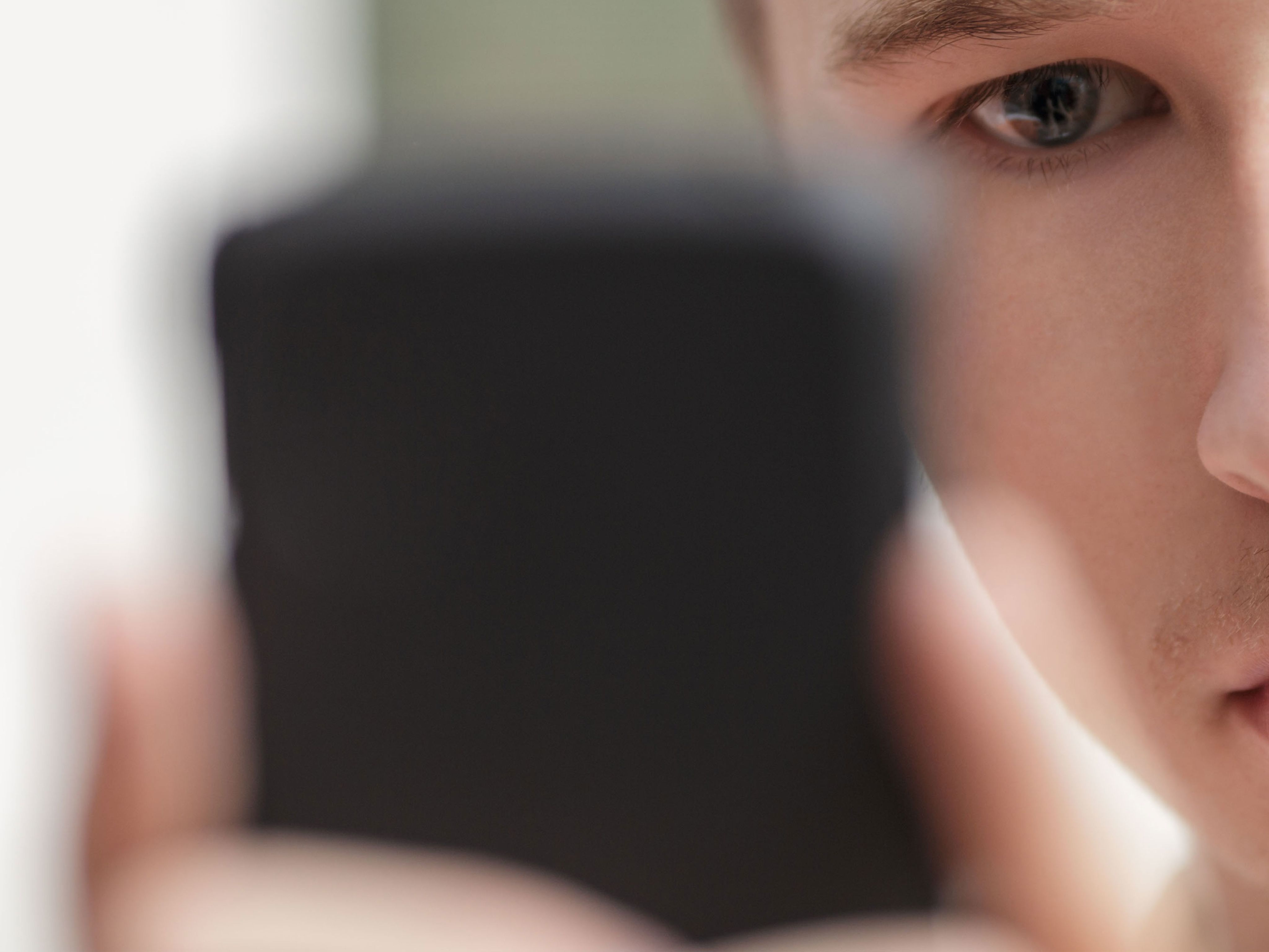 Close up of a man using a smartphone with phone in foreground