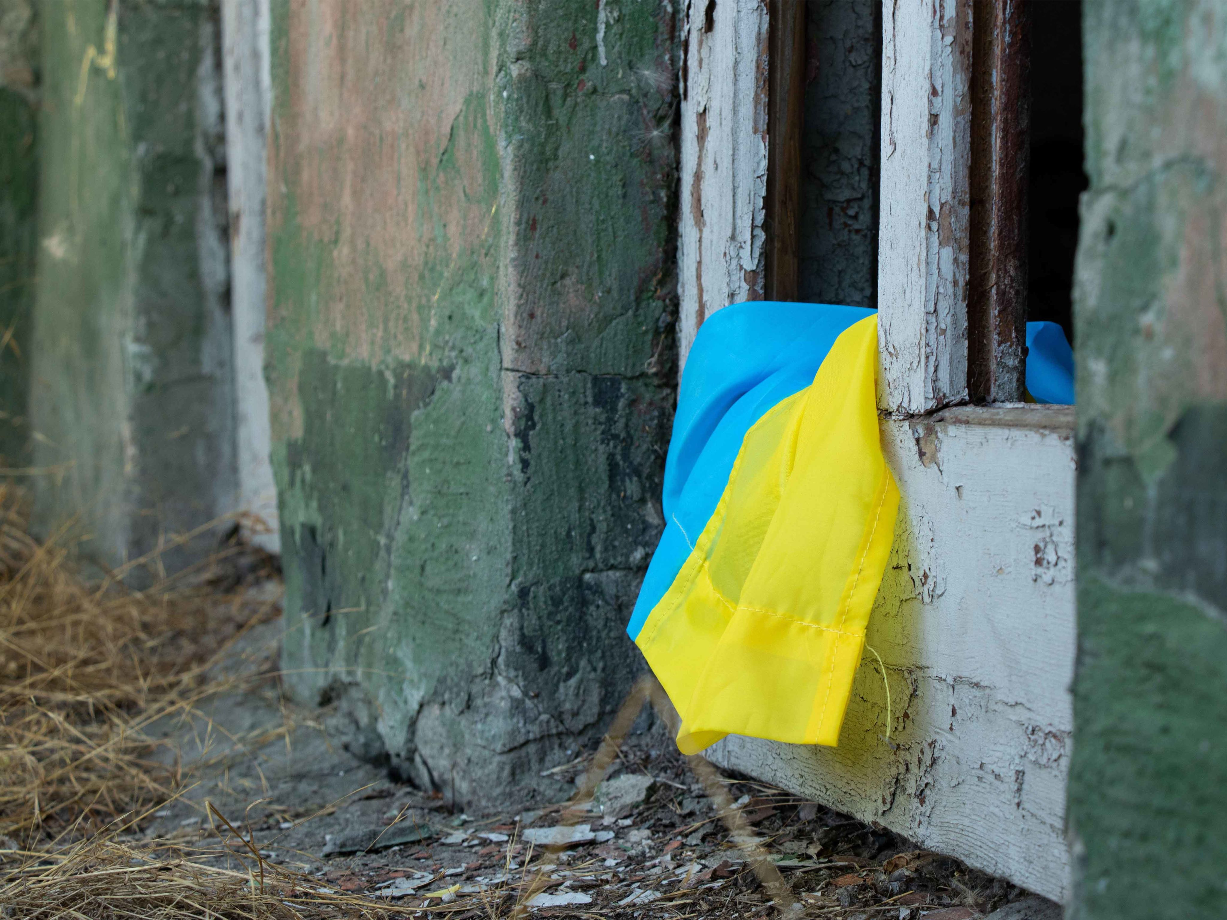 Ukraine flag on a damaged building