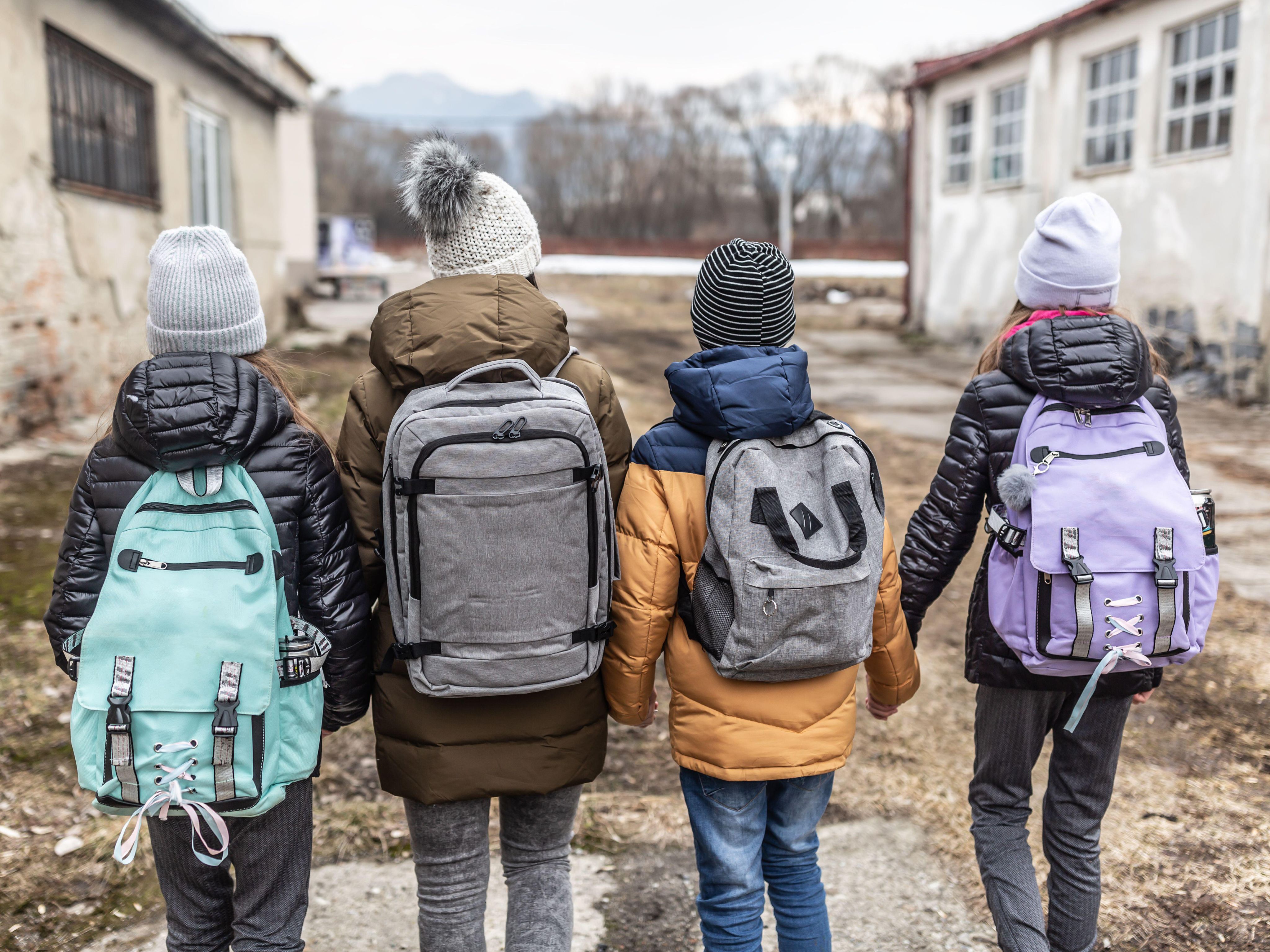 Ukraine refugees walking along damaged street