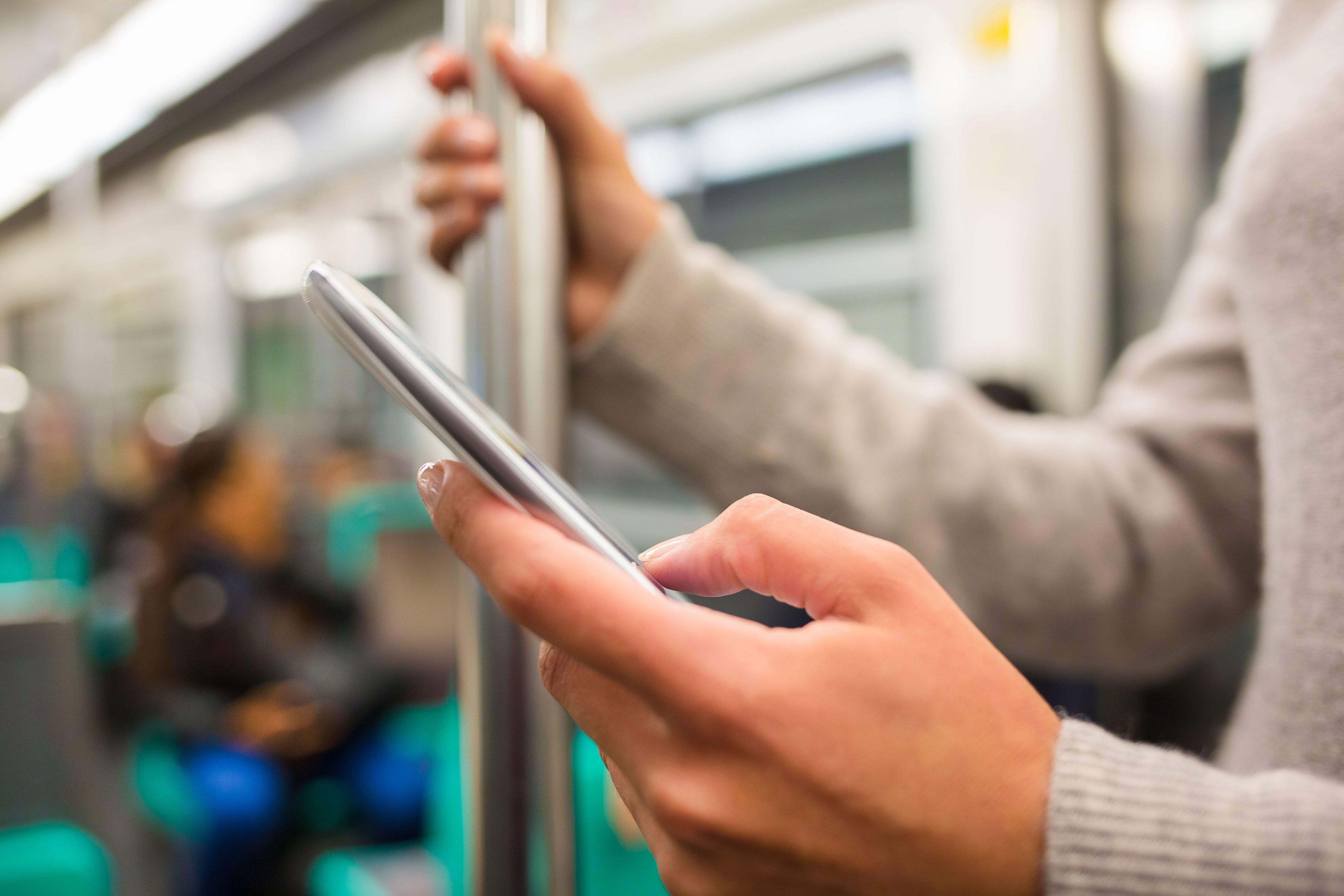 Close up of person using a smartphone on a train