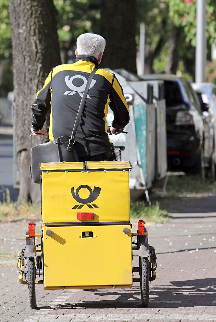Letter carrier of the German Post AG on a cargo bike