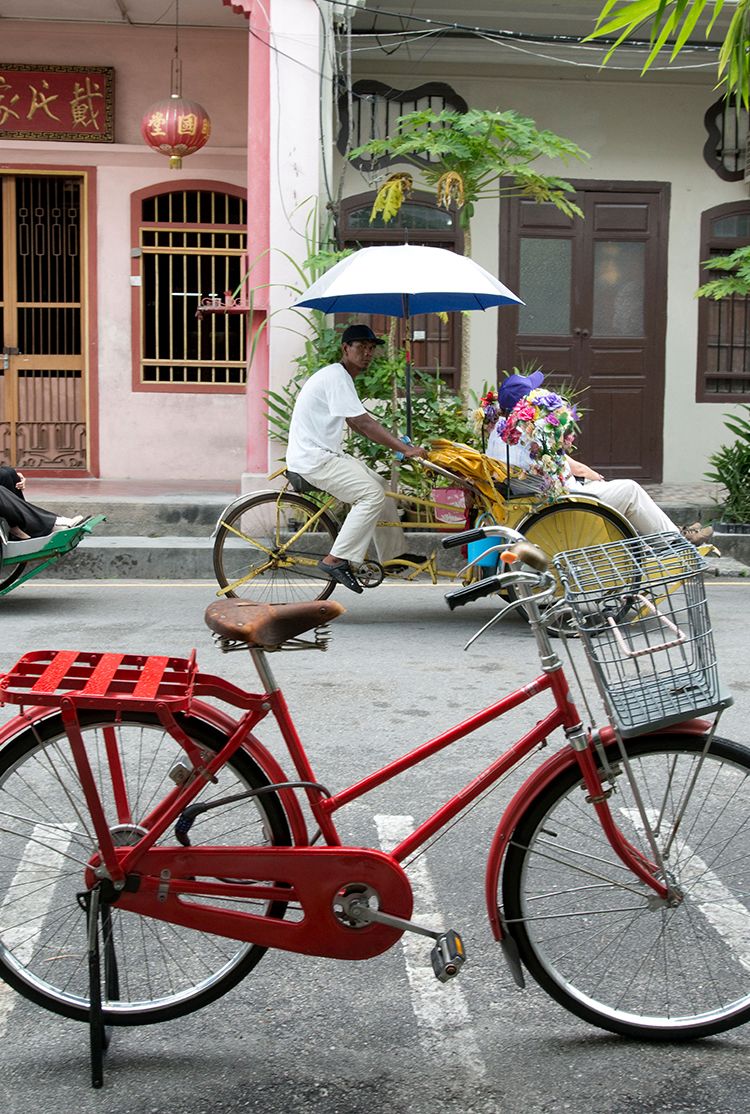Tourists pass by in a fleet of Trishaws in Georgetown, Penang, Malaysia