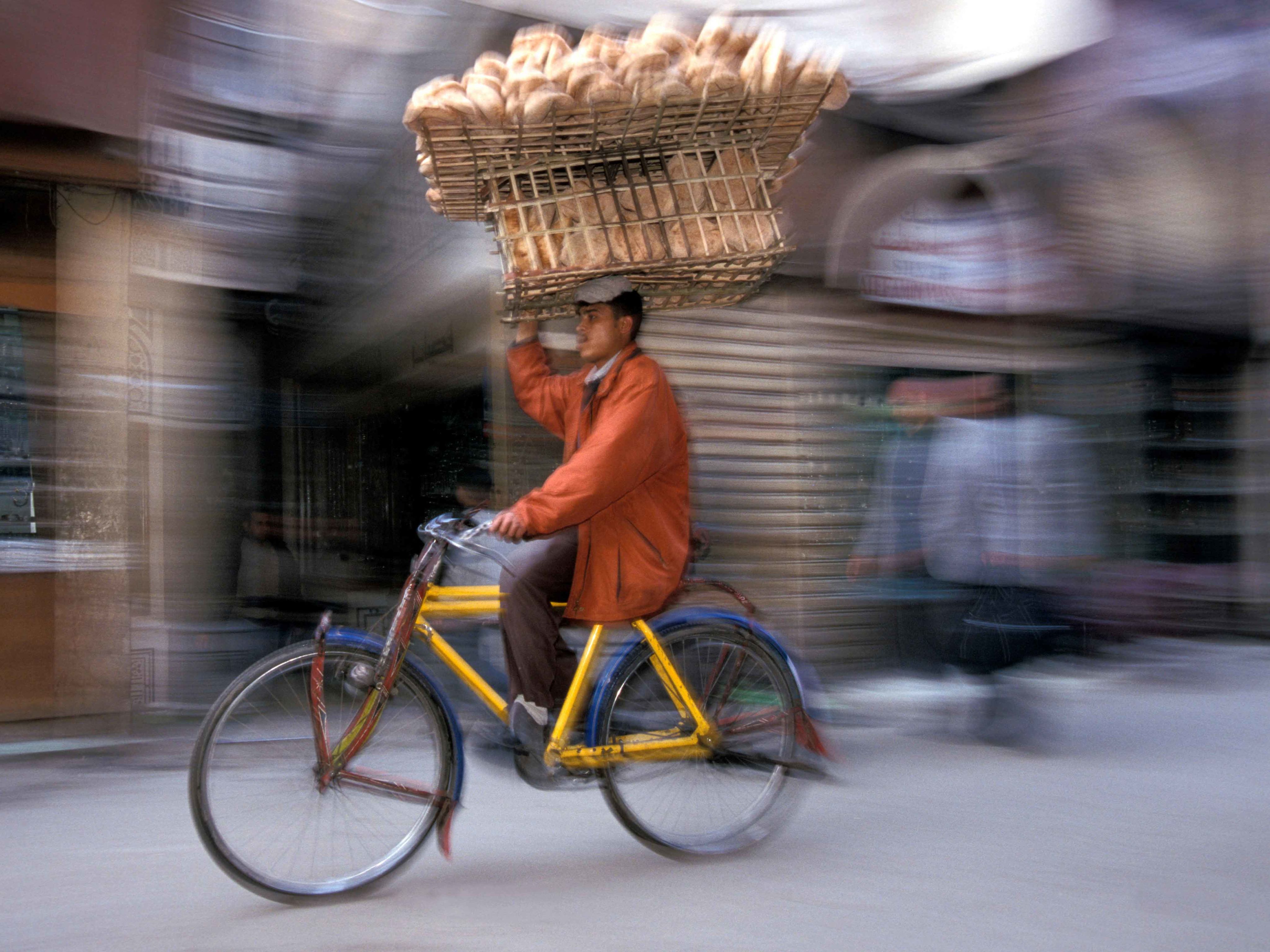 Baker making a bread delivery by cycle in Cairo, Egypt
