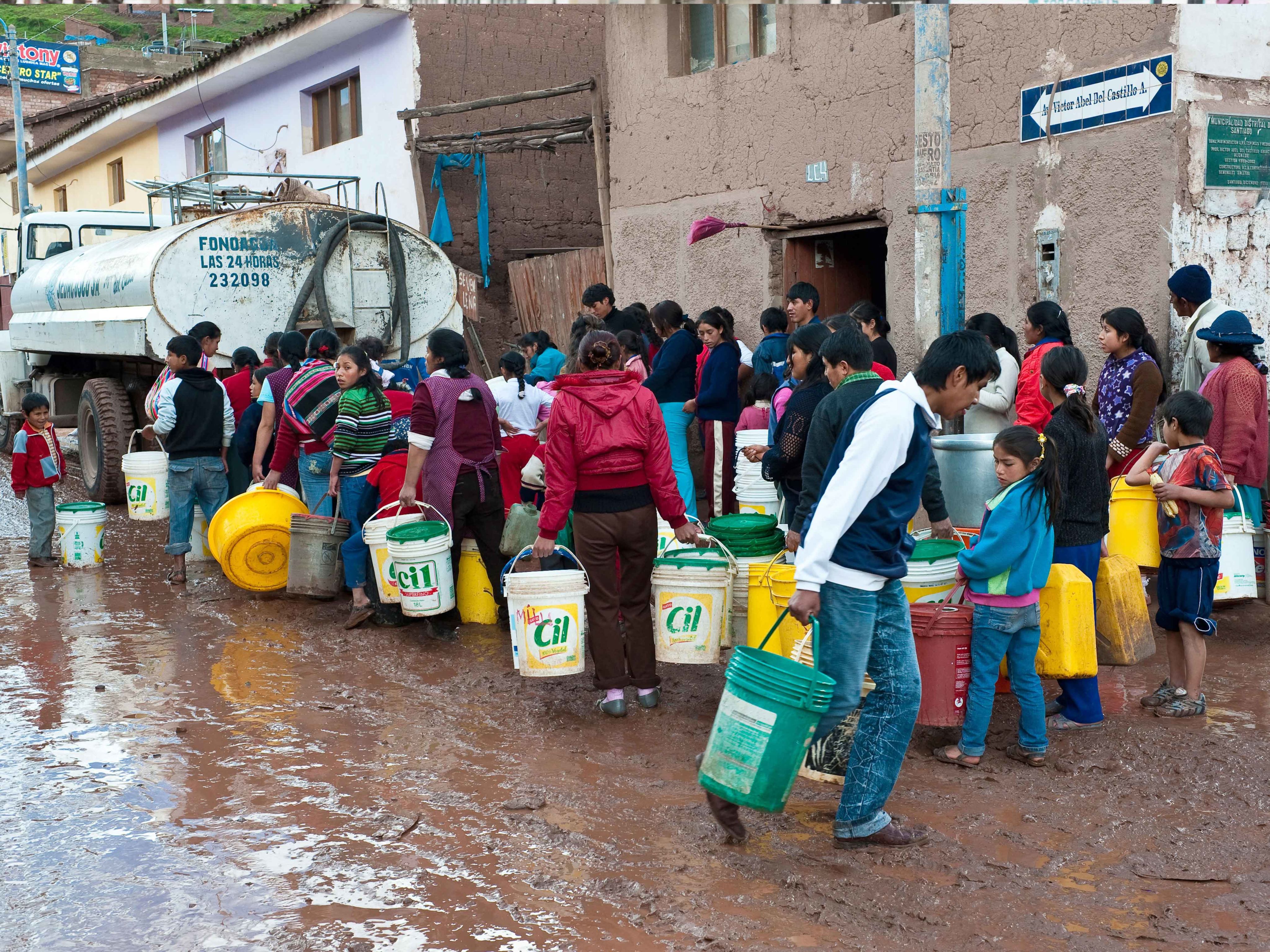 Residents queue for water after a flood in Peru