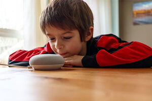 Young boy using a smart speaker