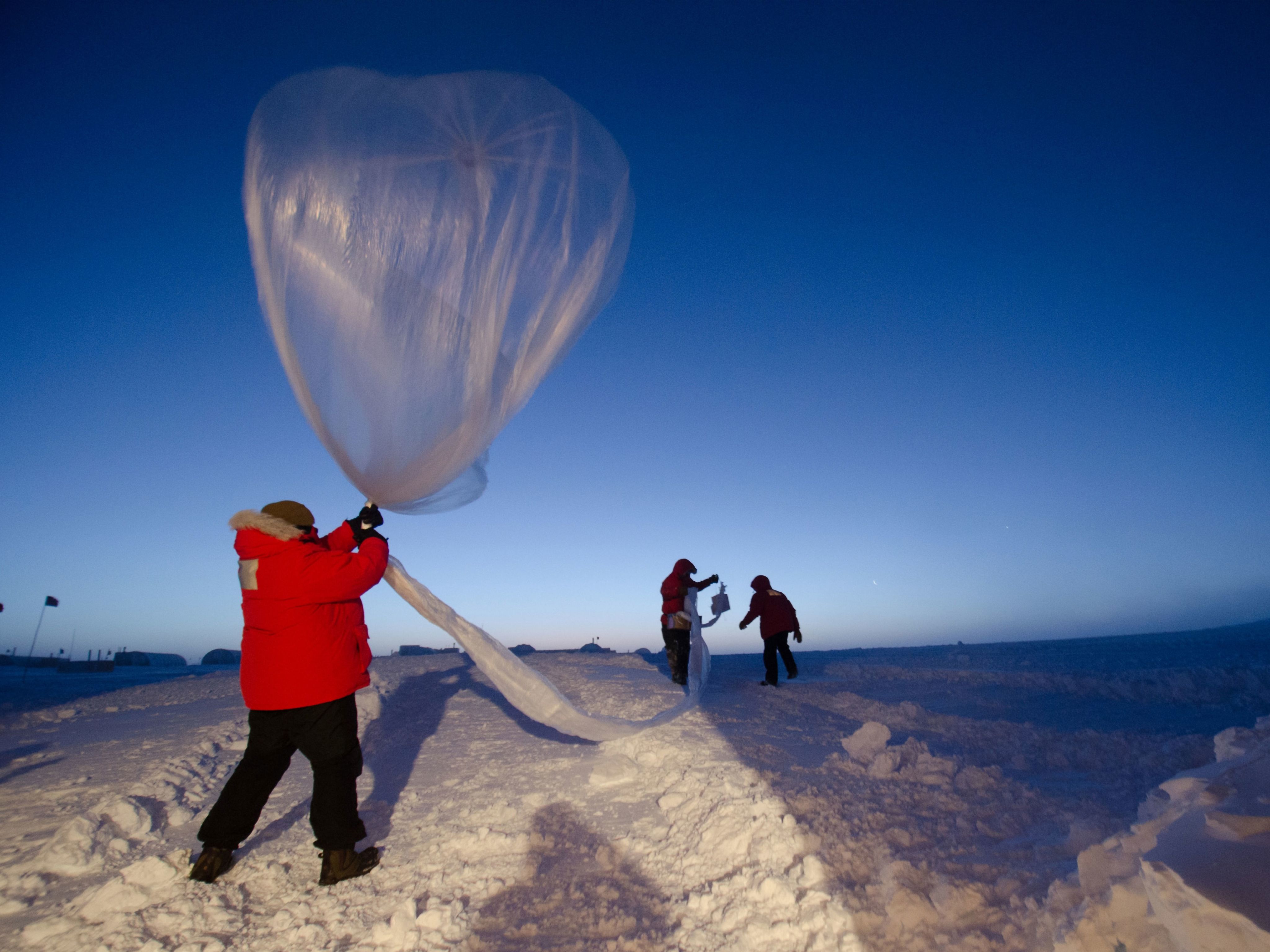Researchers launching a weather balloon at dawn