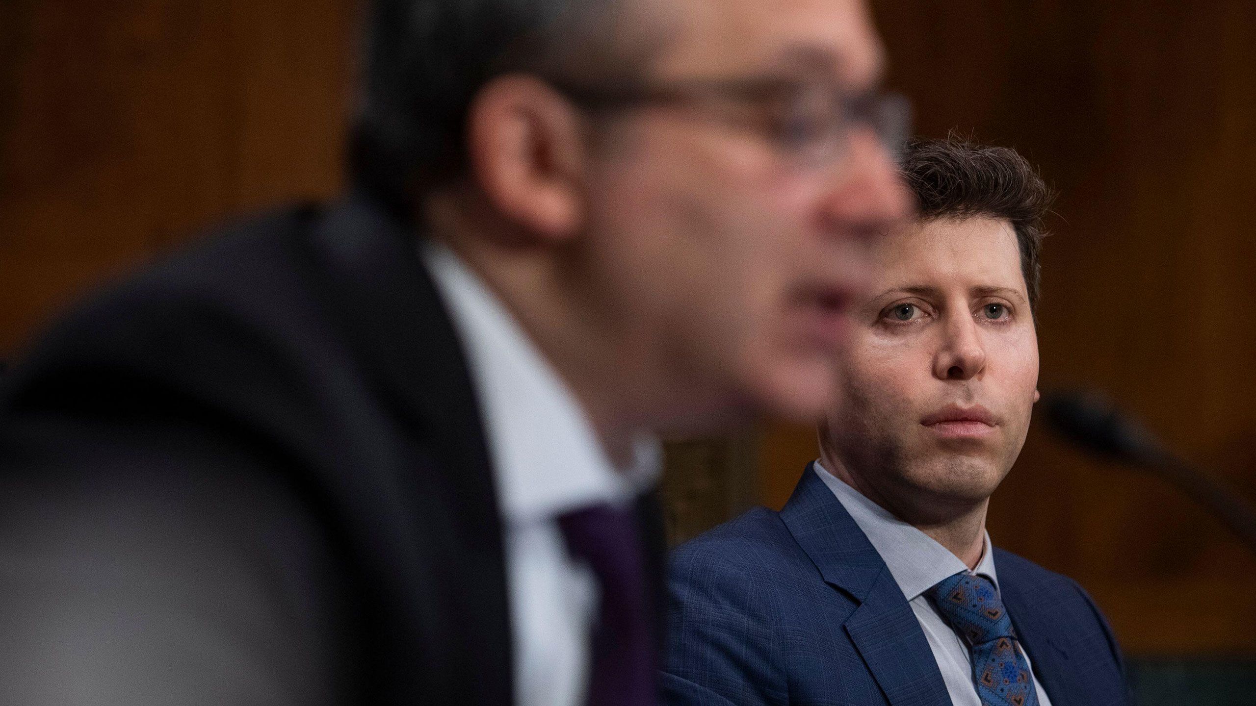 Samuel Altman, CEO, OpenAI, listens while Gary Marcus, Professor Emeritus, New York University, offers his opening statement during a Senate Committee on the Judiciary - Subcommittee on Privacy, Technology, and the Law oversight hearing to examine AI