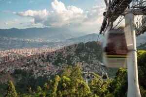 MetroCable public transit system in Medellin, Colombia, cable cars traveling over the city at sunset.