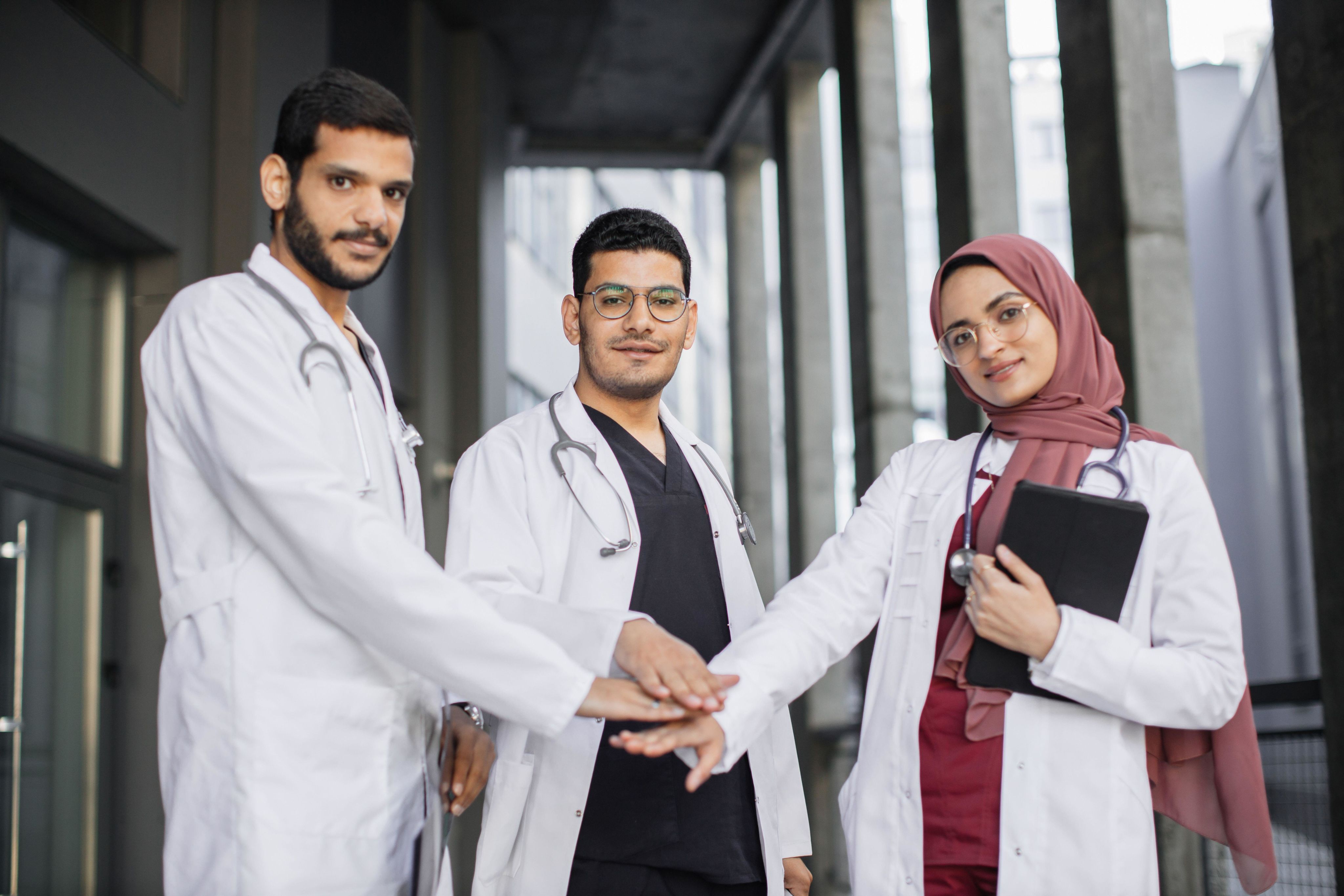 Group of doctors, 2 men and a woman in a hijab.