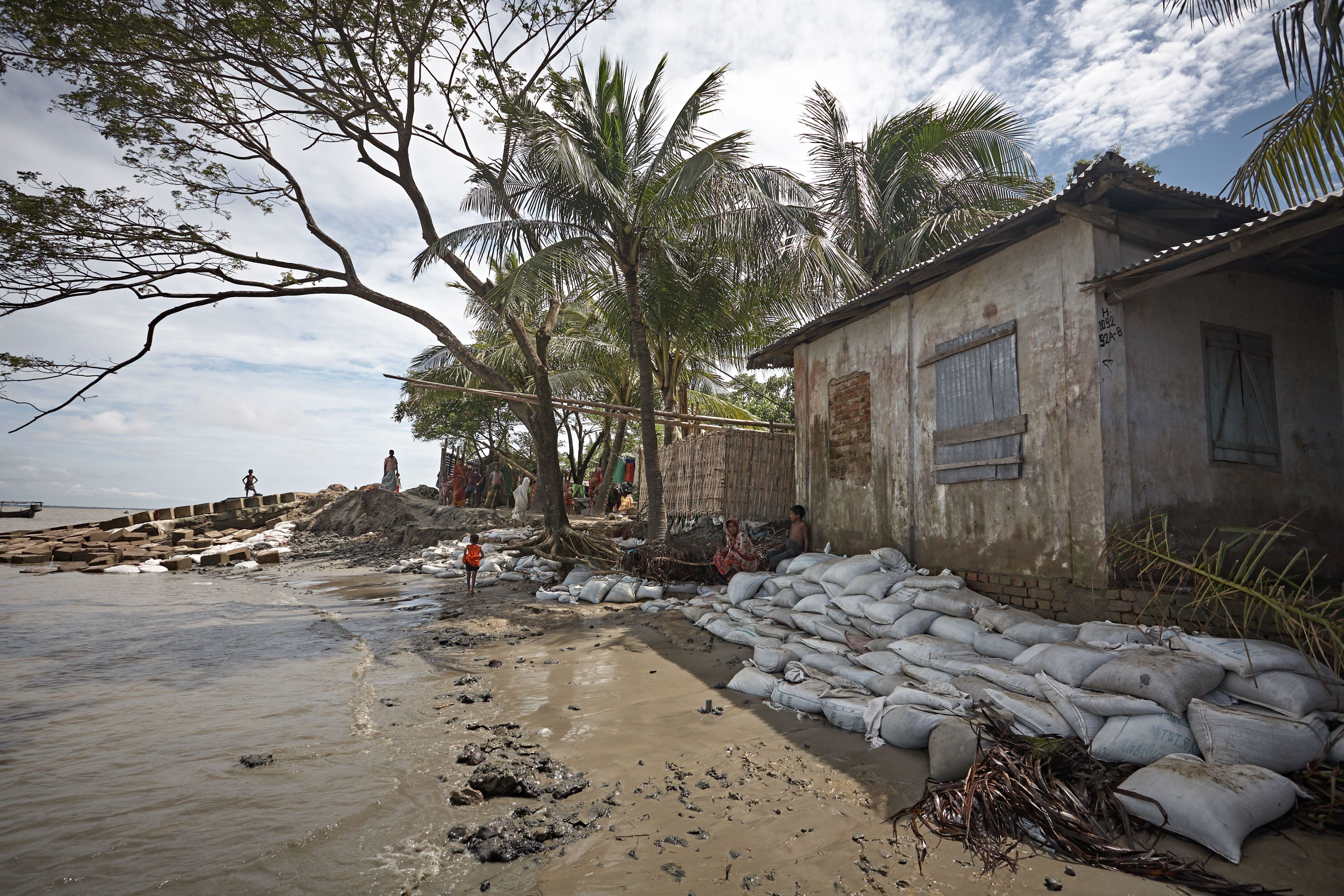 Sandbags on the seashore to protect houses from rising sea levels due to climate change