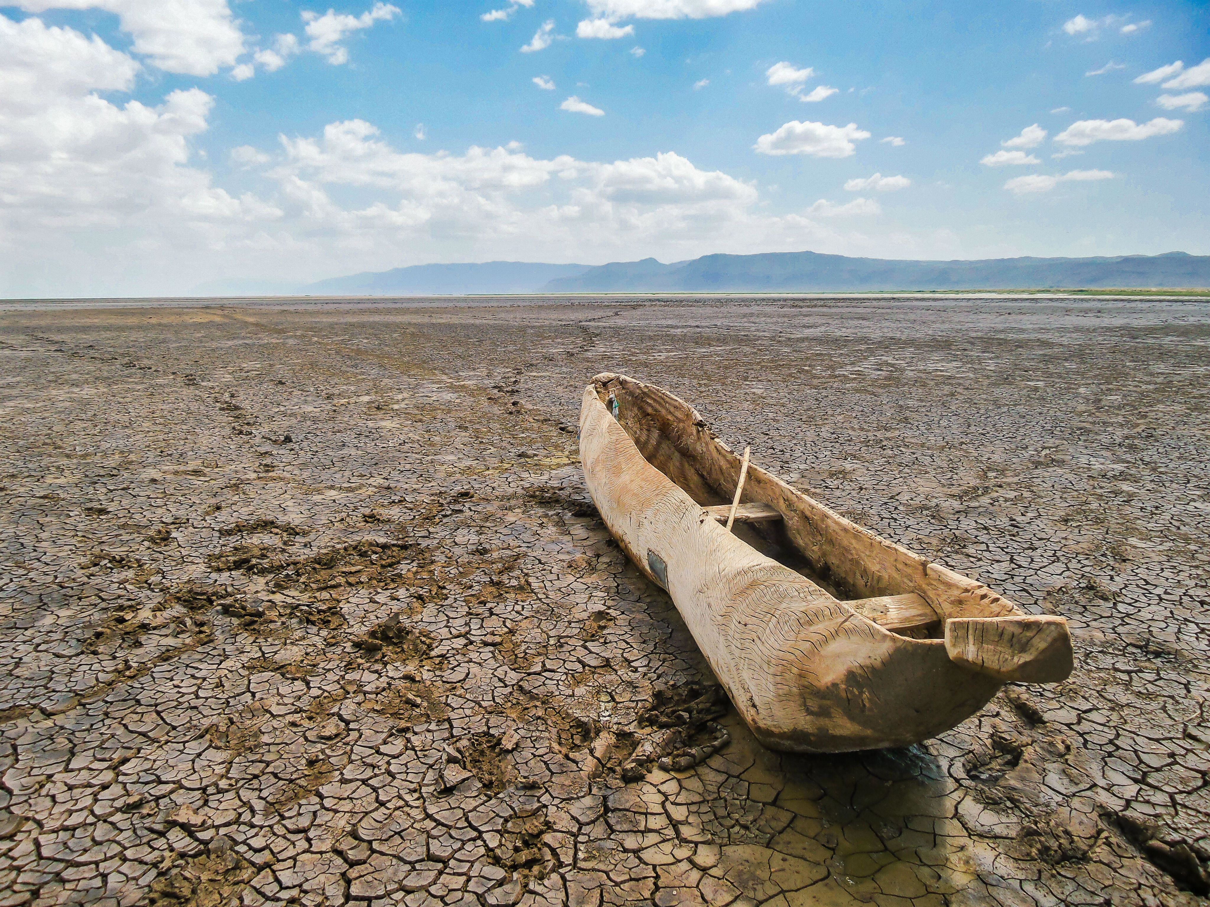 A dry river bed in Africa with a wooden boat