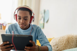 Boy with headphones on using a tablet