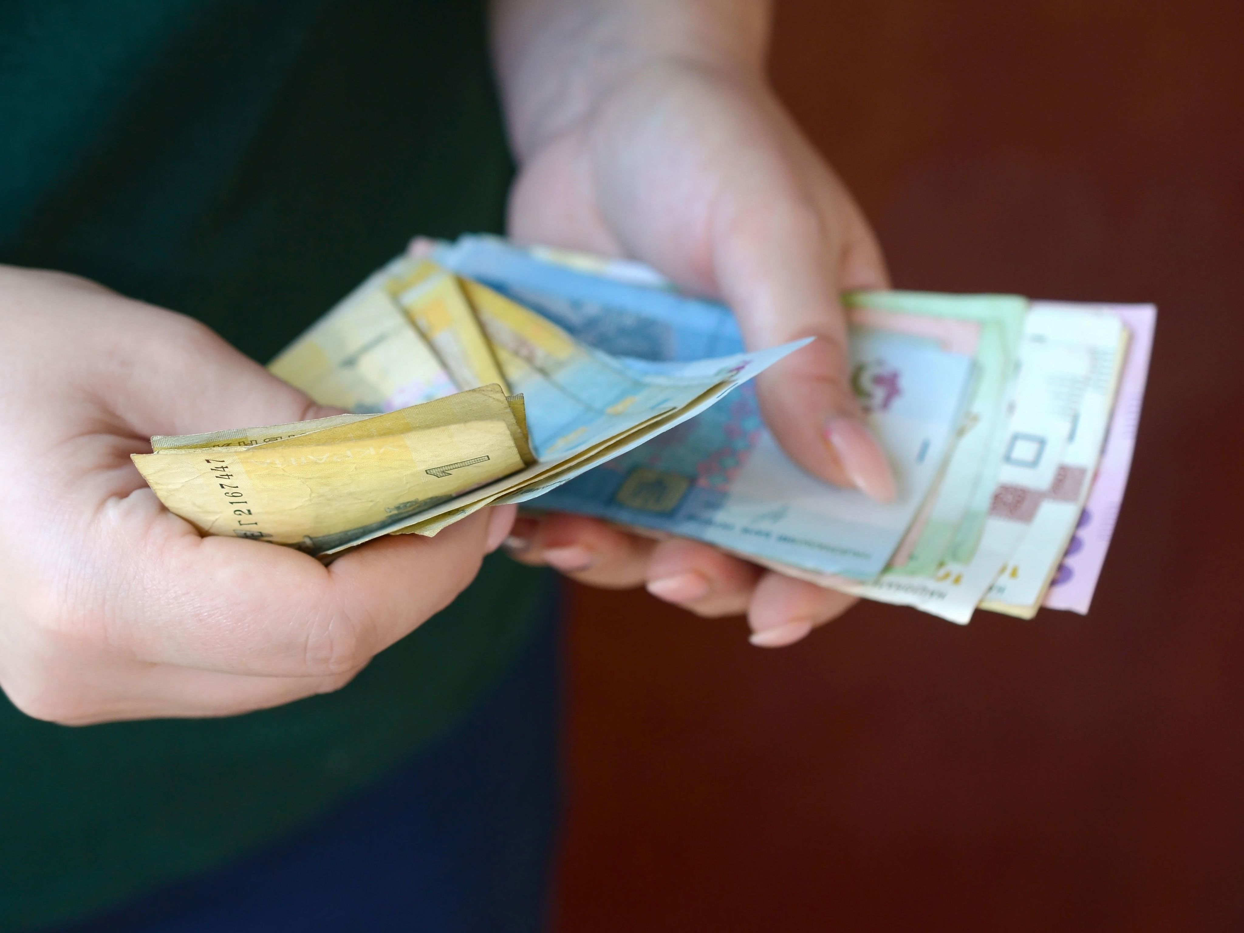 Female hands counts big amount of Ukrainian money during salary period in Ukraine
