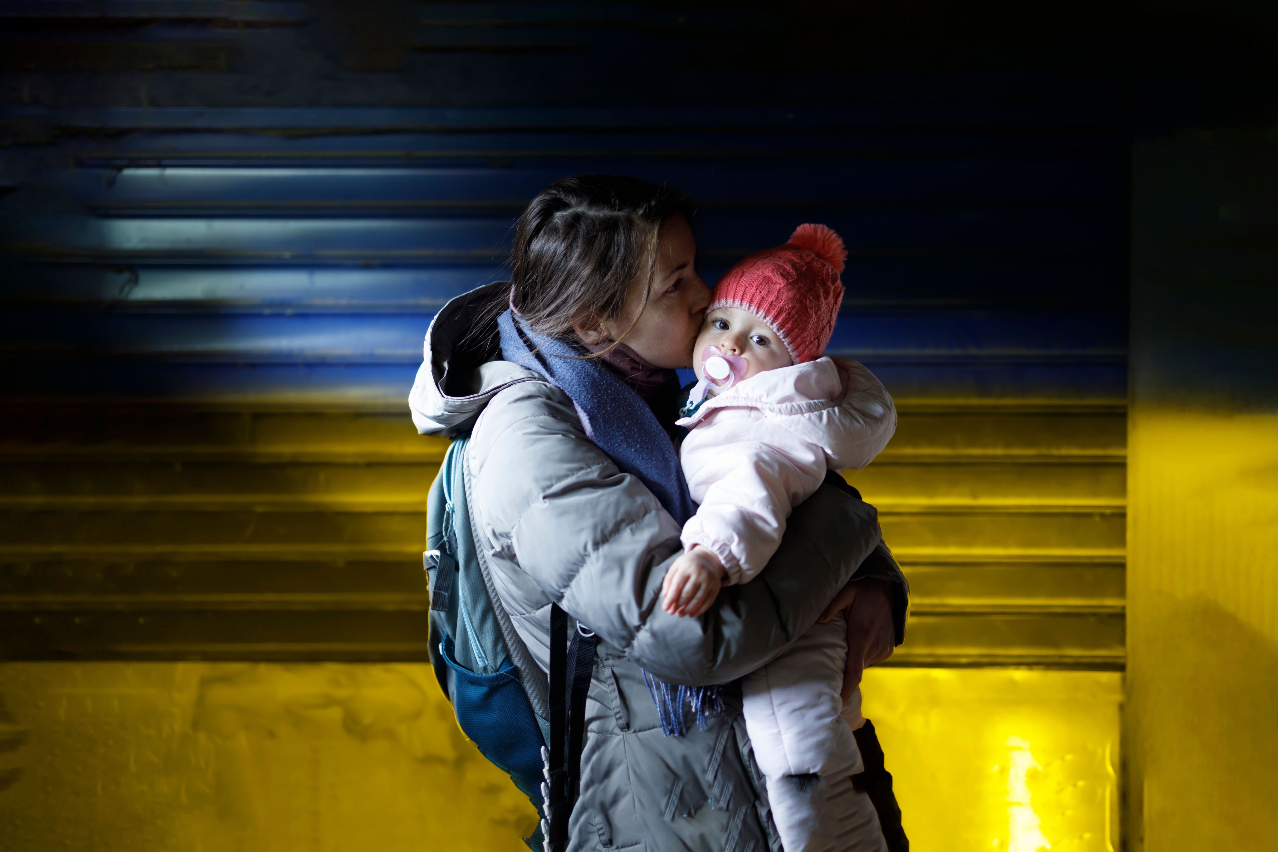 A mother holding her young child in a bomb shelter in Ukraine