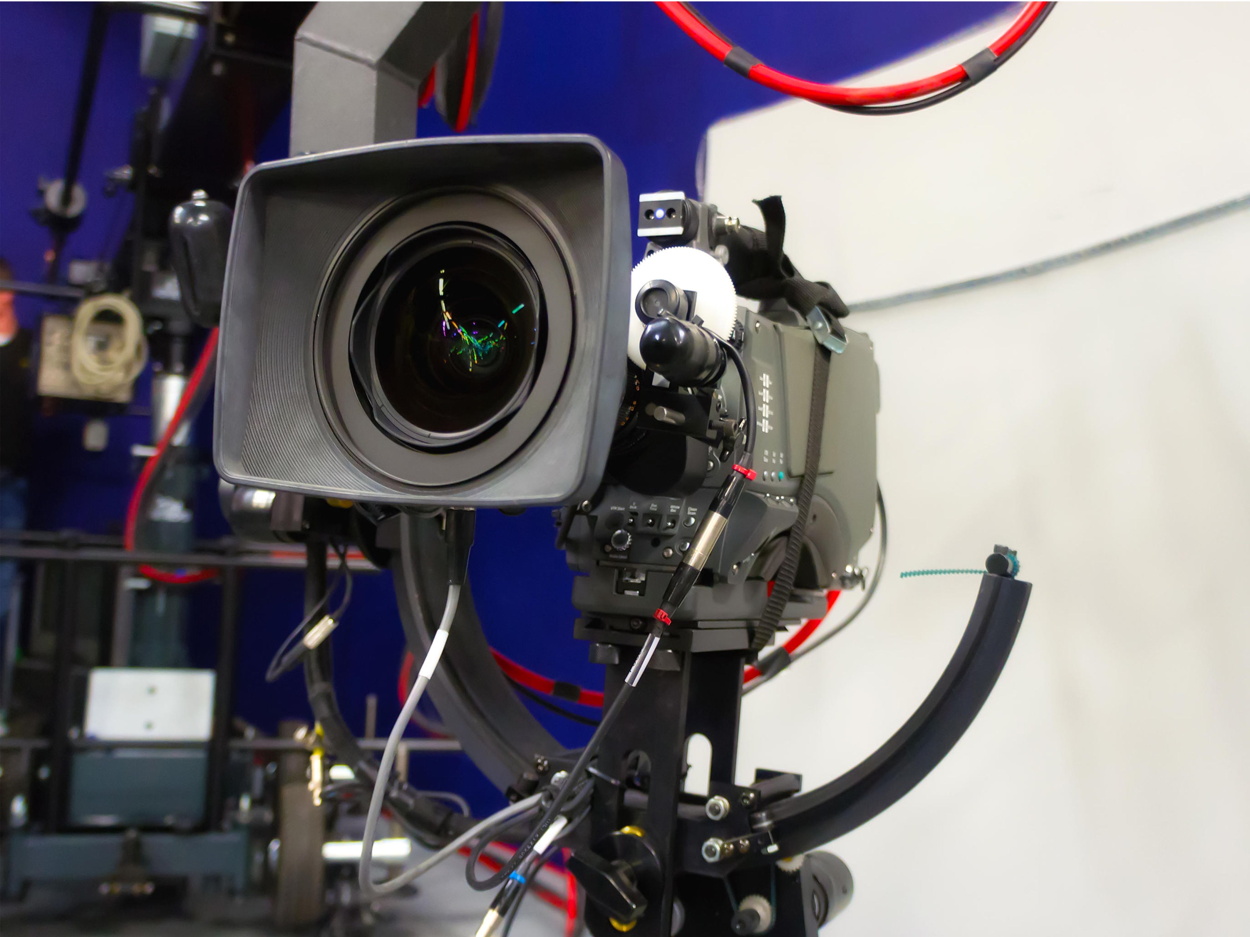 TV camera in TV studio with colours of Russian flag on walls in background