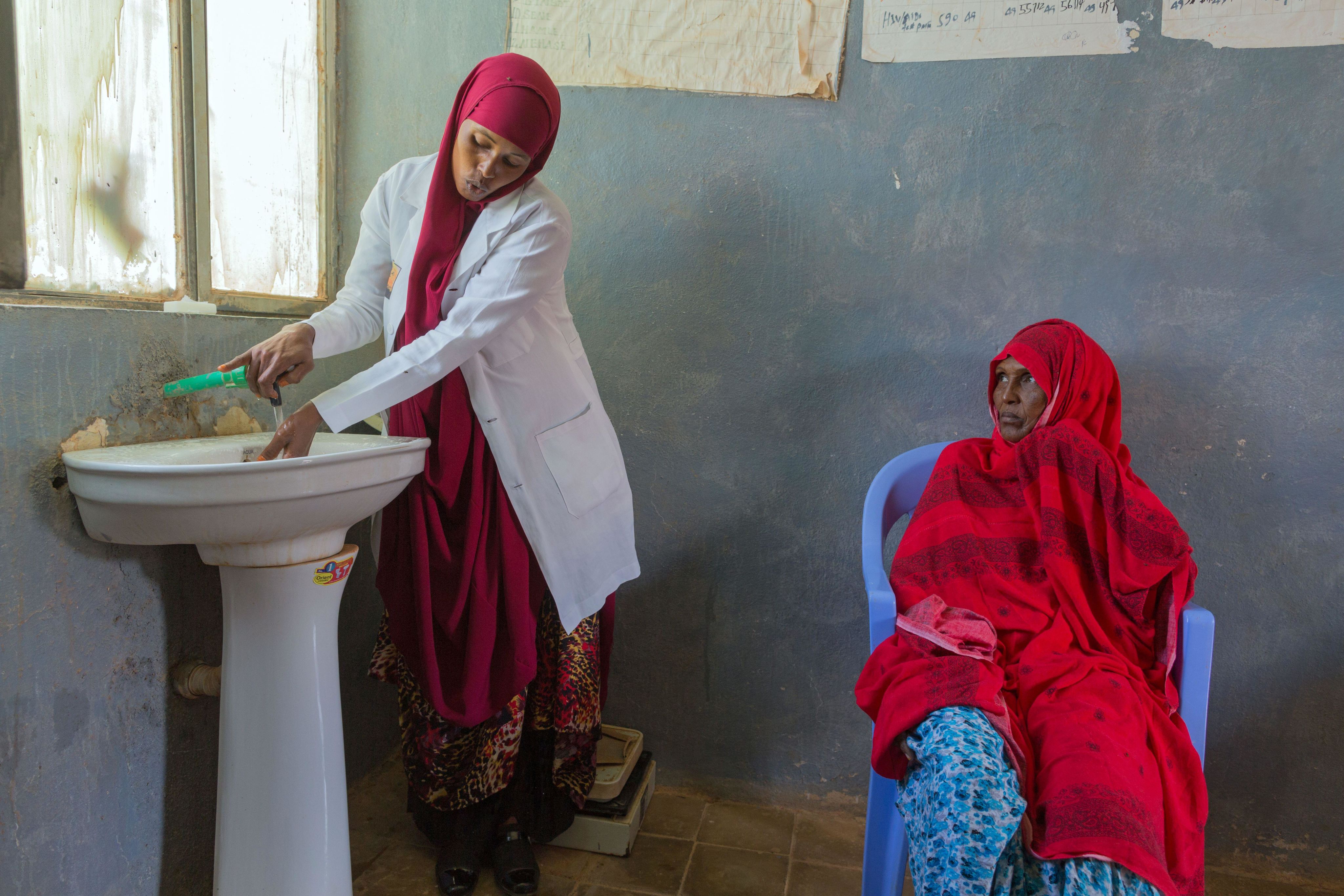 In a treatment room of the Denan Hospital a doctor washes her hands in a sink under running water