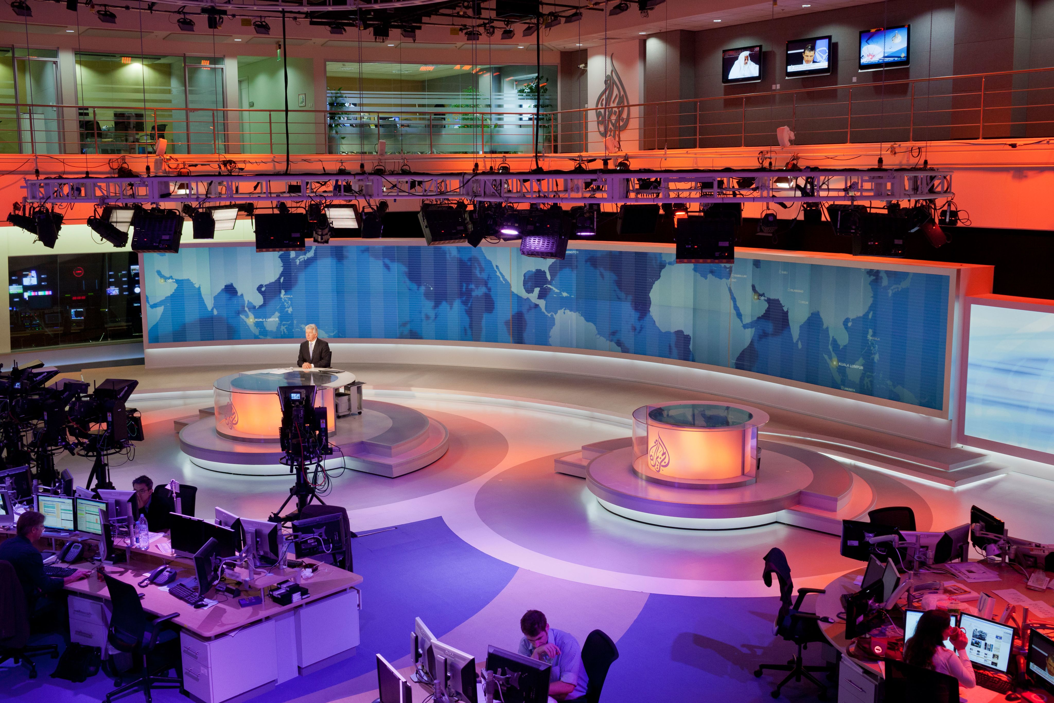 News Anchor, David Foster on camera in the main studio newsroom of Al Jazeera English in Doha, Qatar