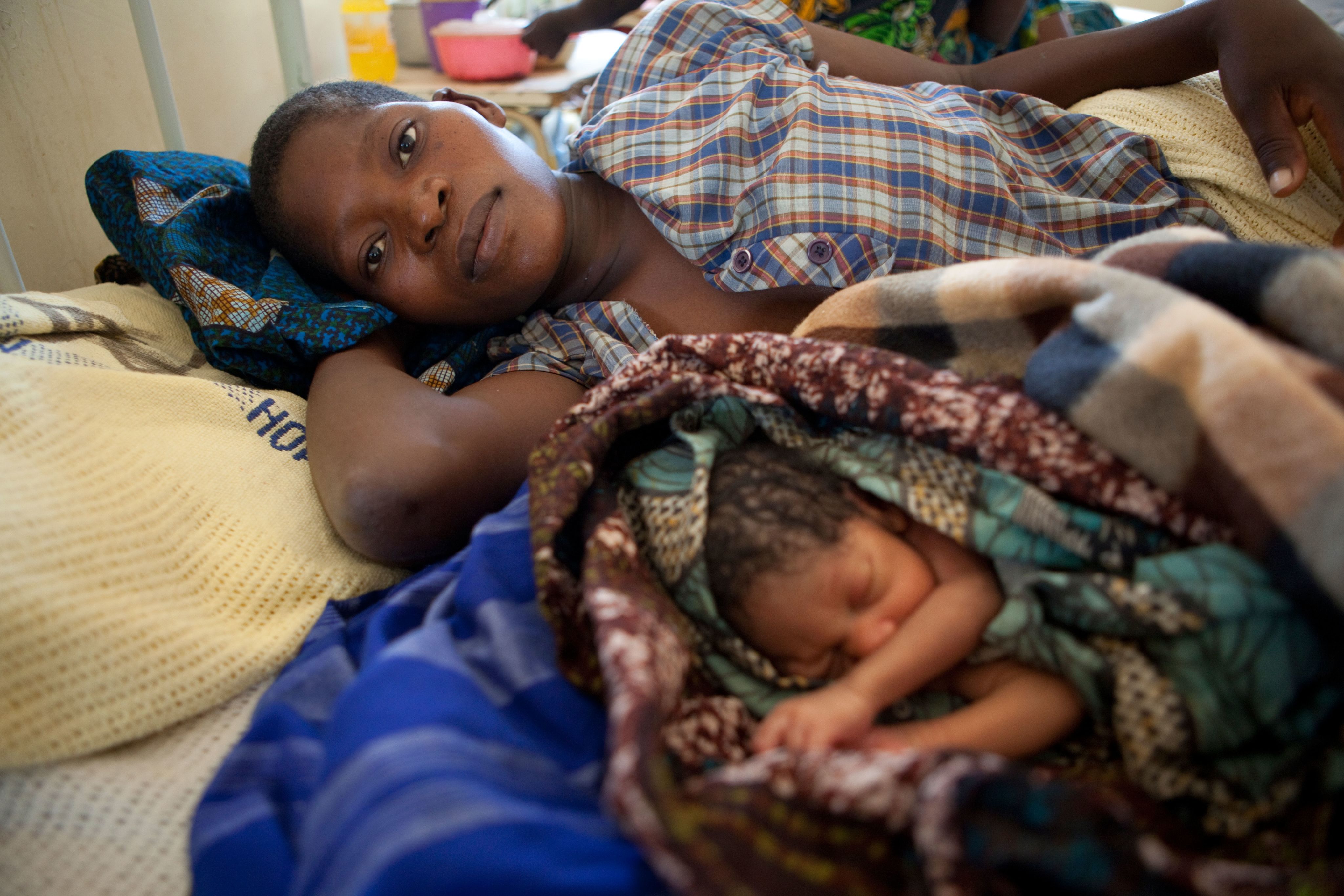 A mother and her newborn child lay in bed in the anti-natal unit of a hospital in Dedza, Malawi