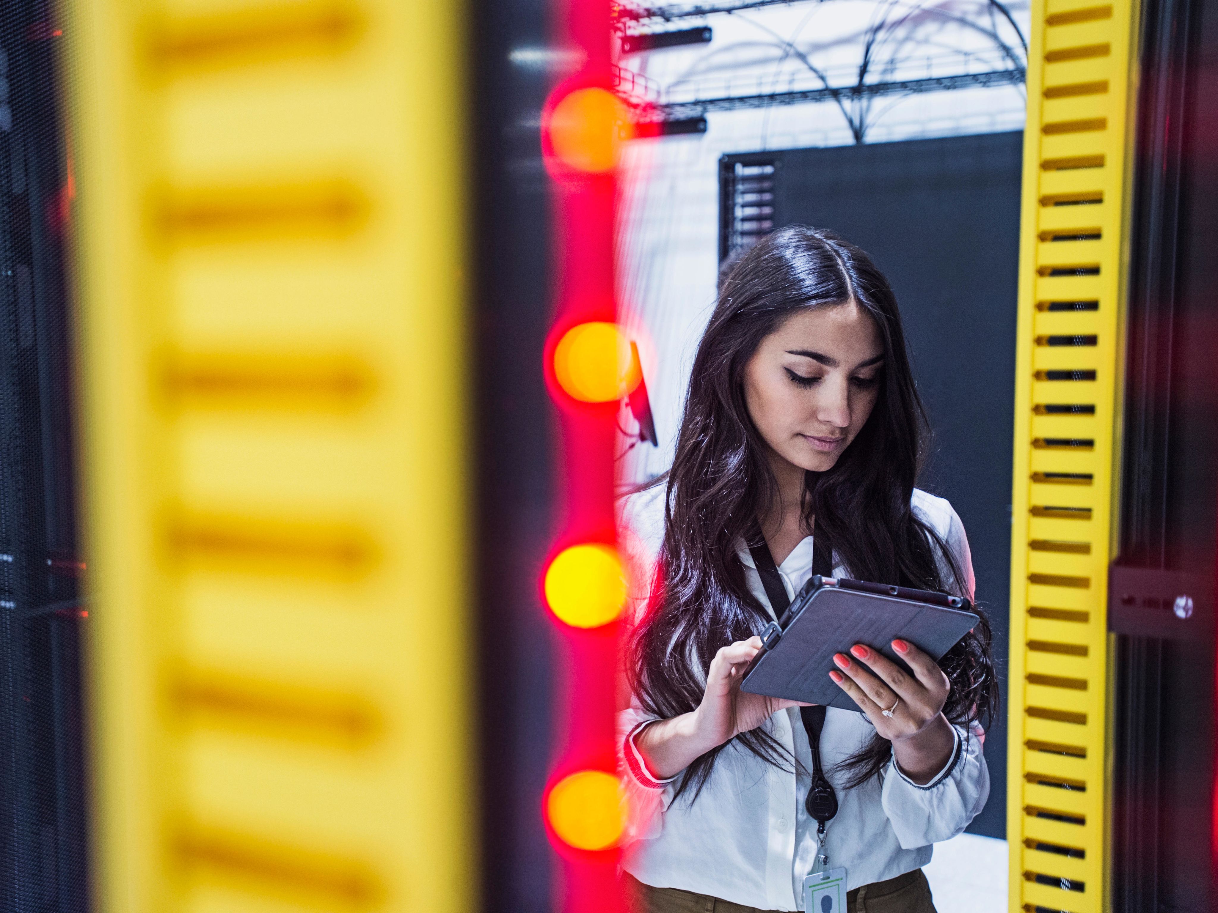 Woman using tablet computer in data center