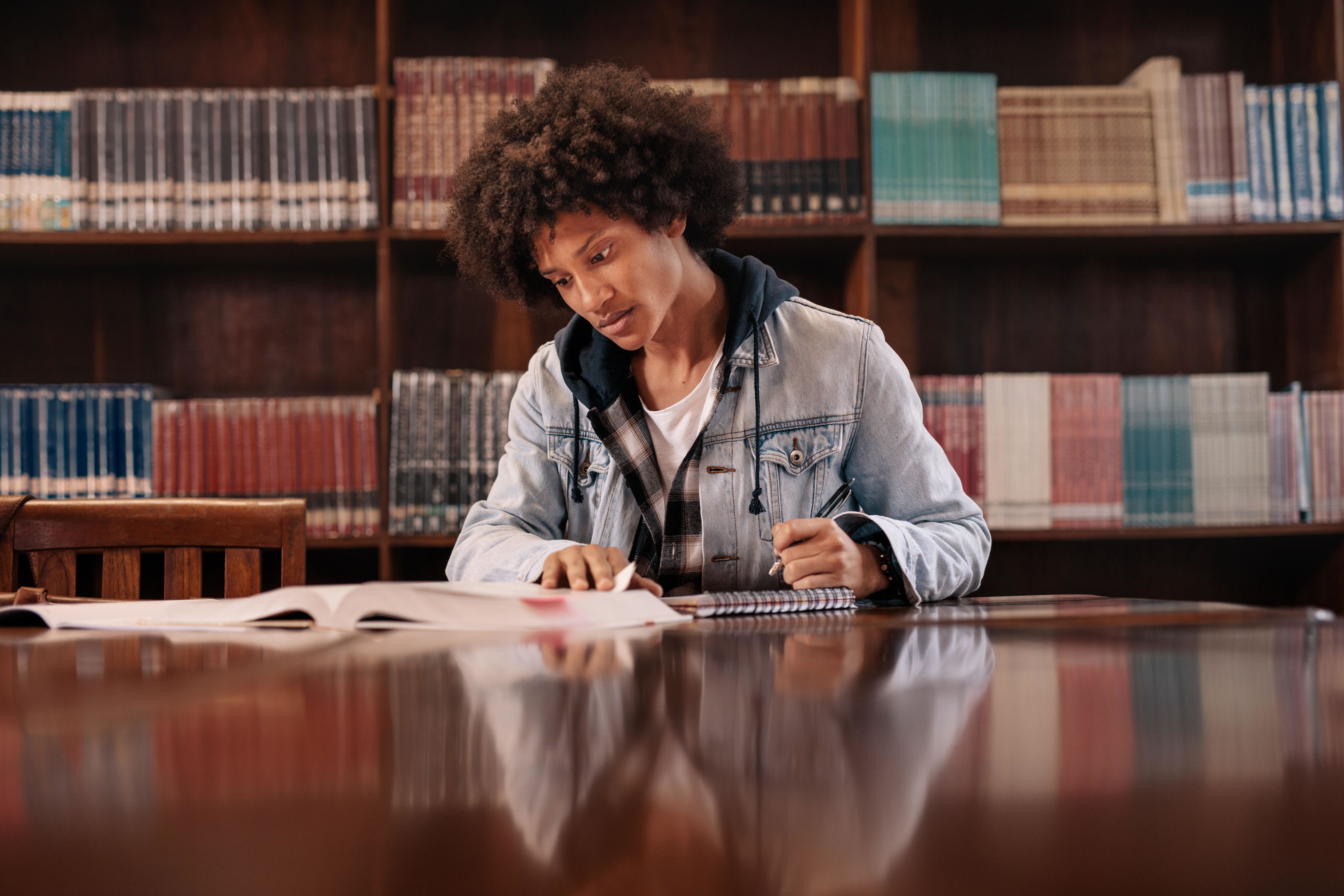 Black student studying in a traditional university library.