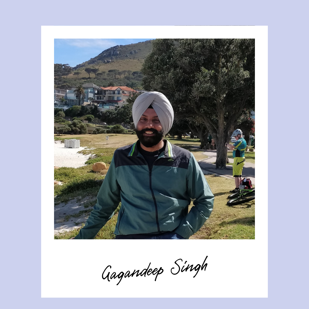 Photo of Gagandeep Singh standing outside smiling, wearing a green and black jacket and white turban.