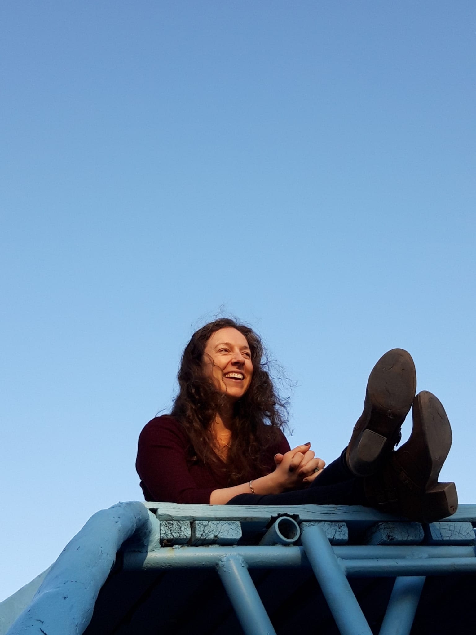 Photo of a woman with brown hair and a black shirt with a black background