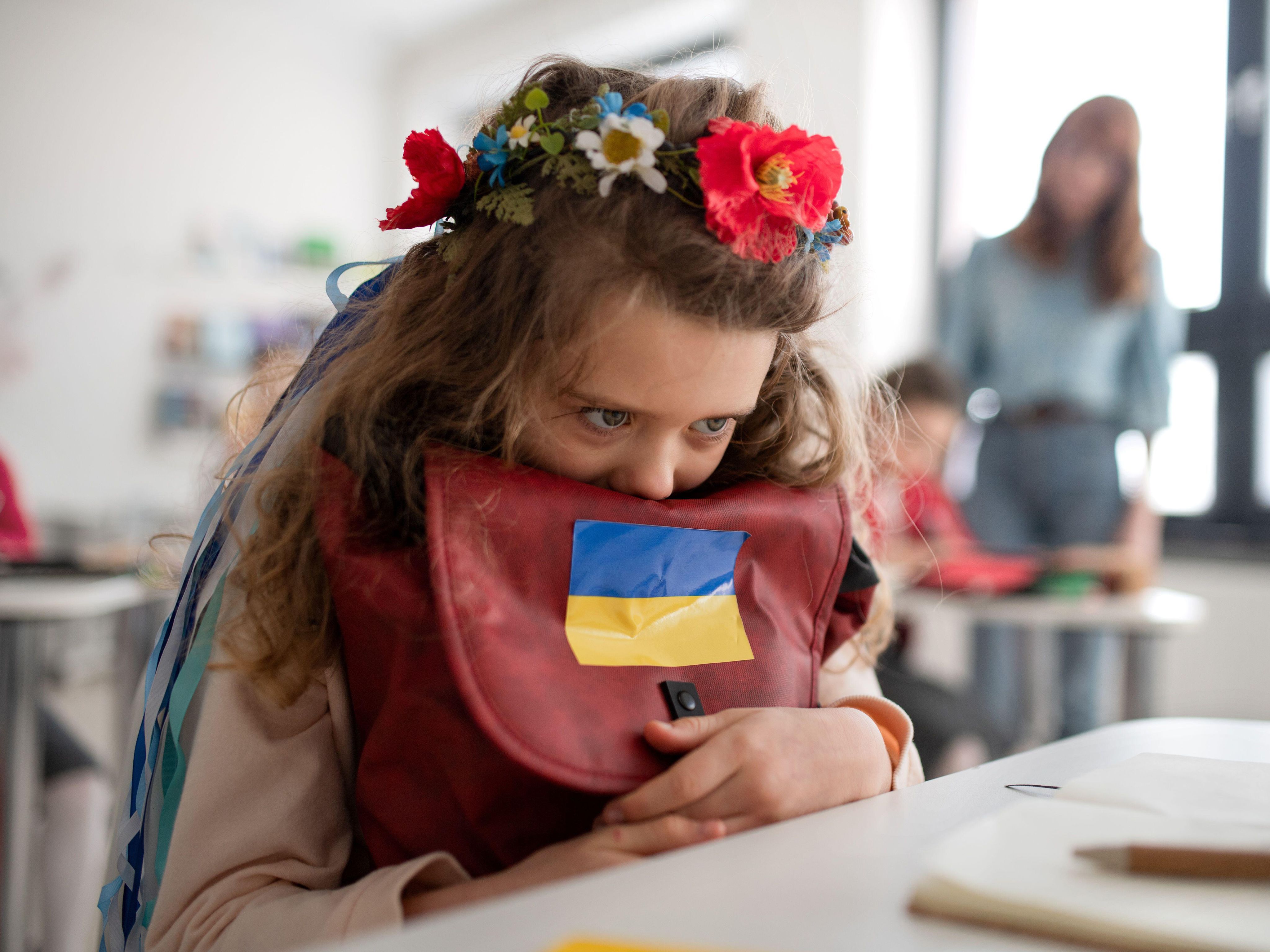 Ukrainian child at school in classroom clutching bag
