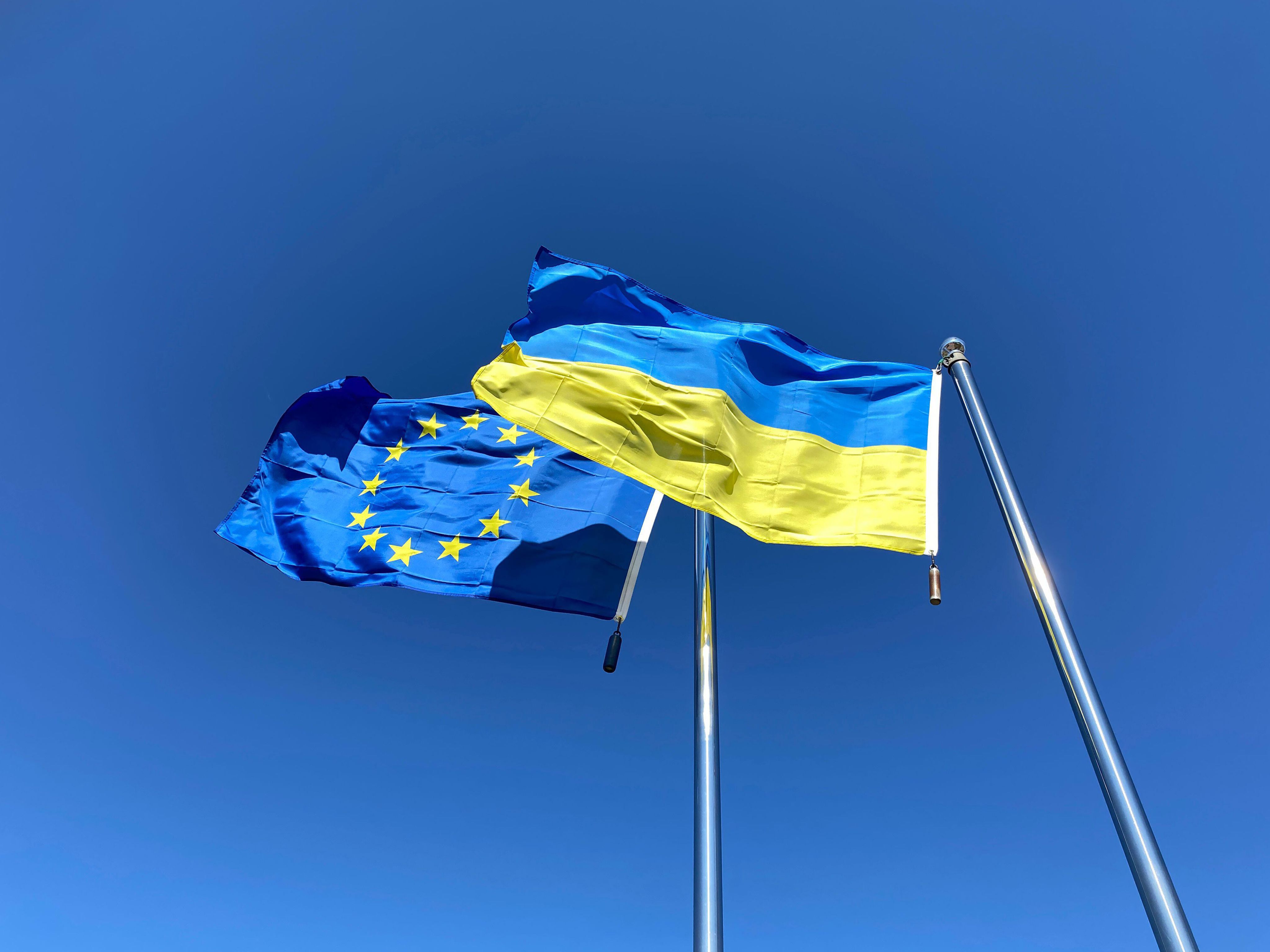 Eu and Ukraine flags with blue sky background