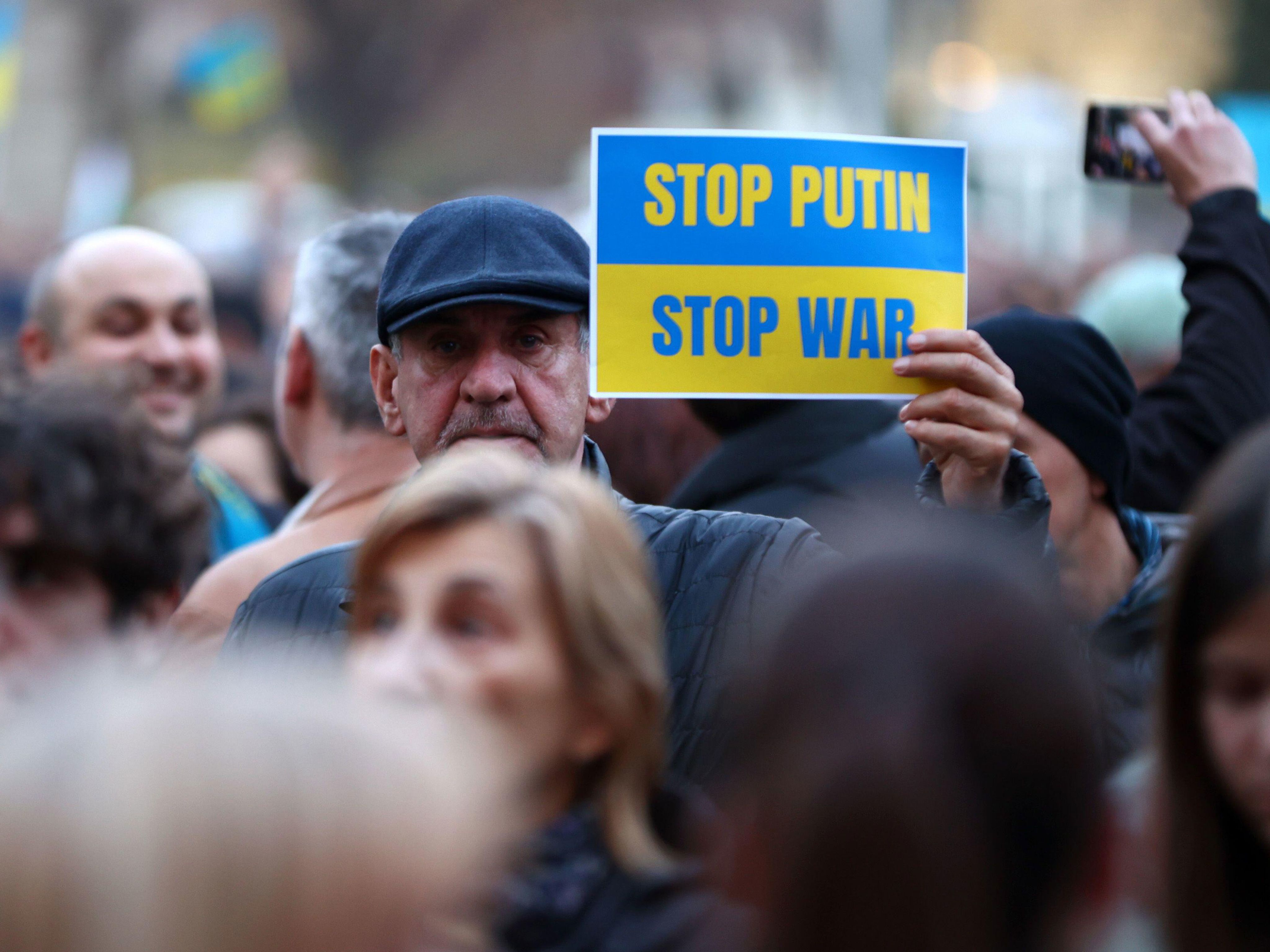 Anti-war protestor holding card that says 'Stop Putin Stop war'