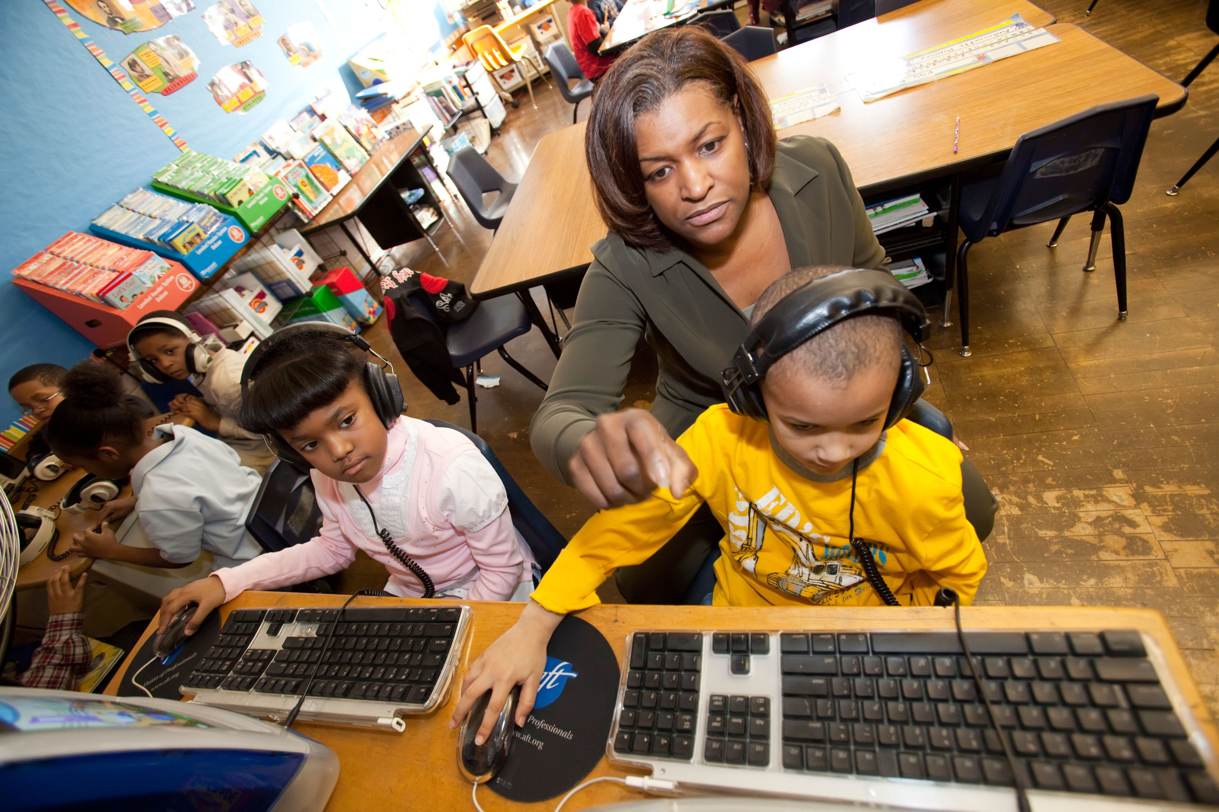 Teacher supporting student on a computer in a U.S. school