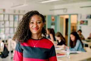 Teacher in front of students smiling.
